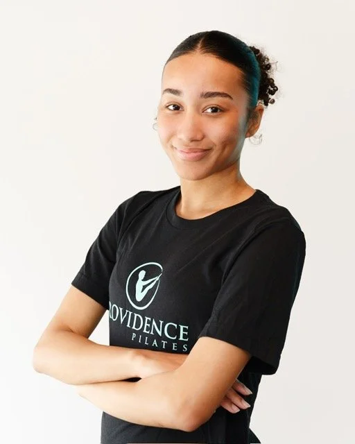 front desk associate young woman standing with arms crossed posing for a headshot