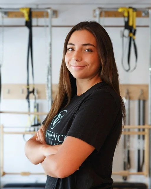 smiling woman standing in Providence Pilates studio posing for a headshot