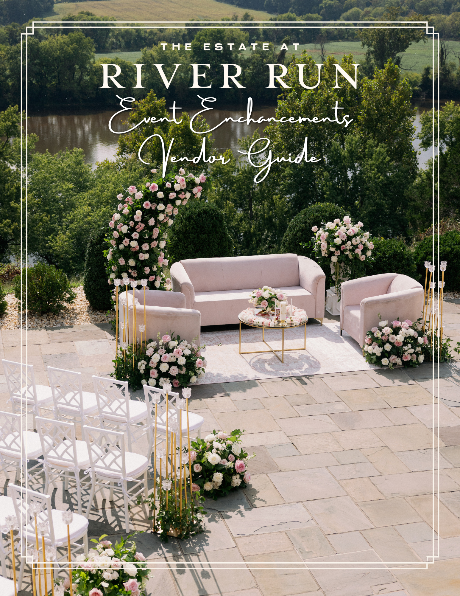 Outdoor wedding ceremony setup with pink sofas, floral arrangements, and chairs overlooking a river and green landscape.