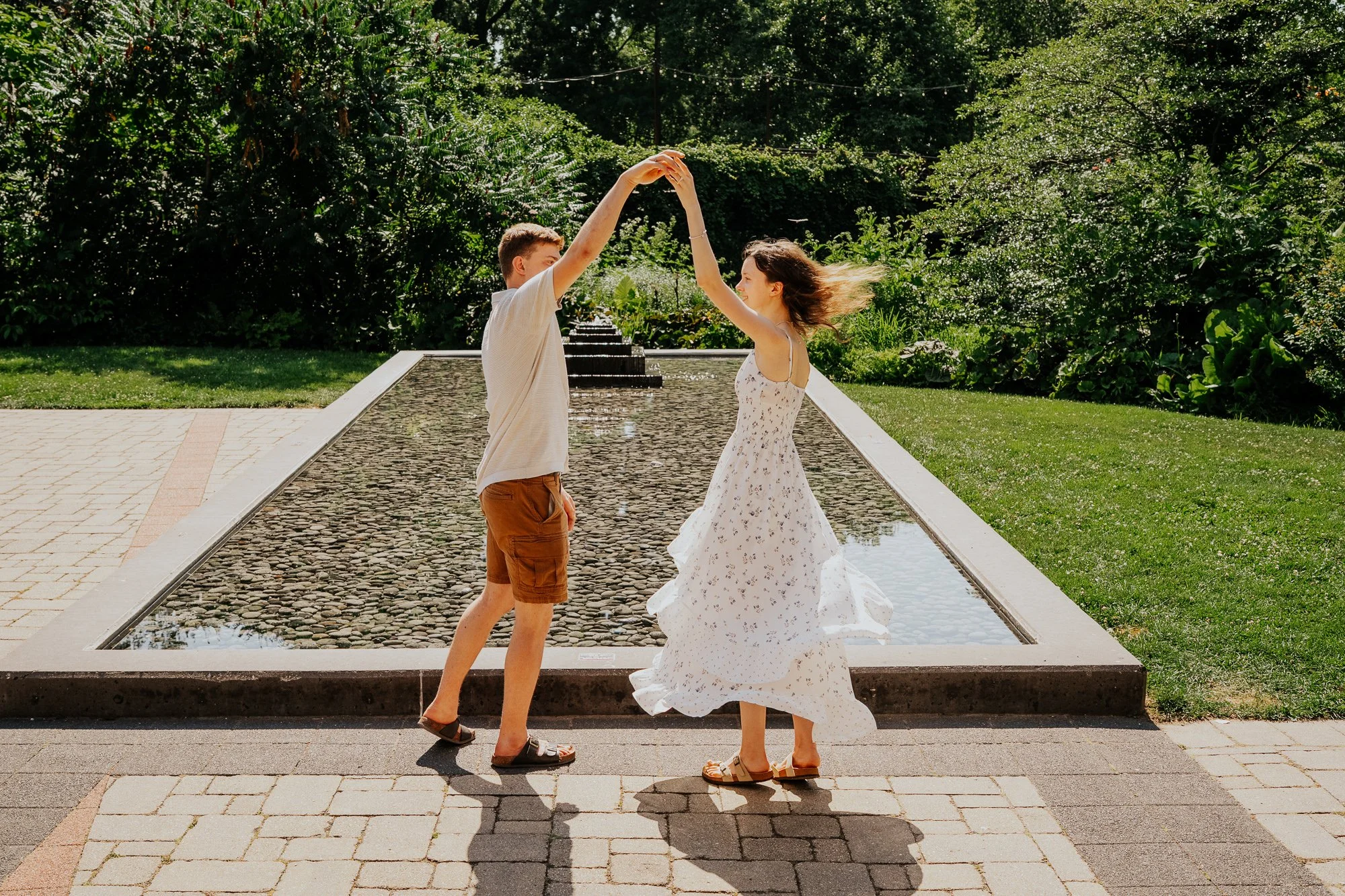 women in a white dressing getting twirled in front of fountain in madison