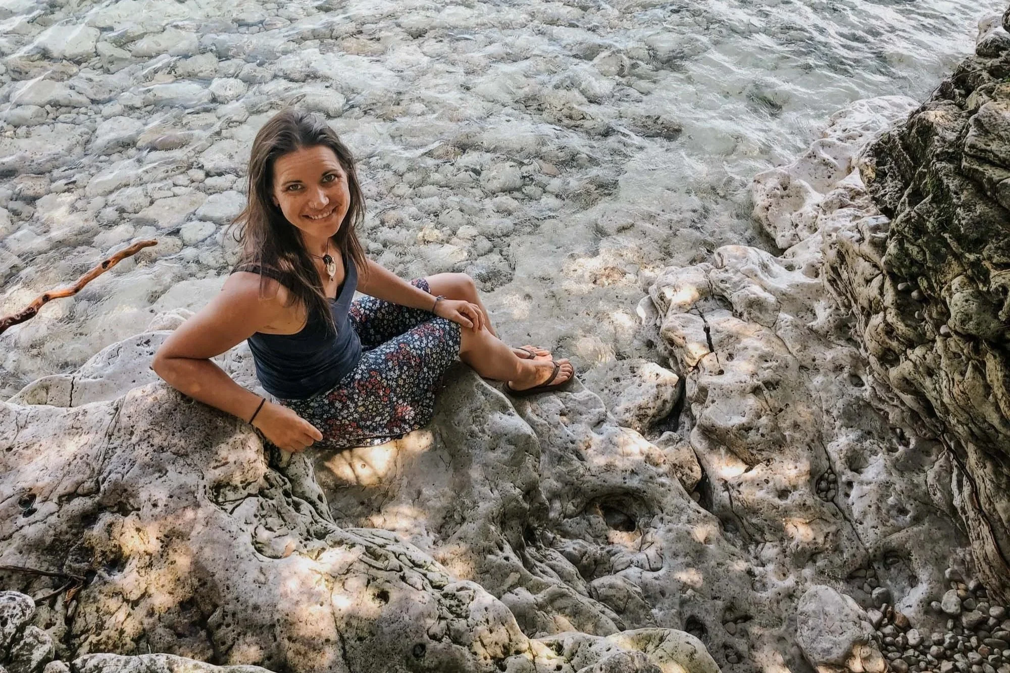 Becky sitting on the white rocks on a door county shoreline.