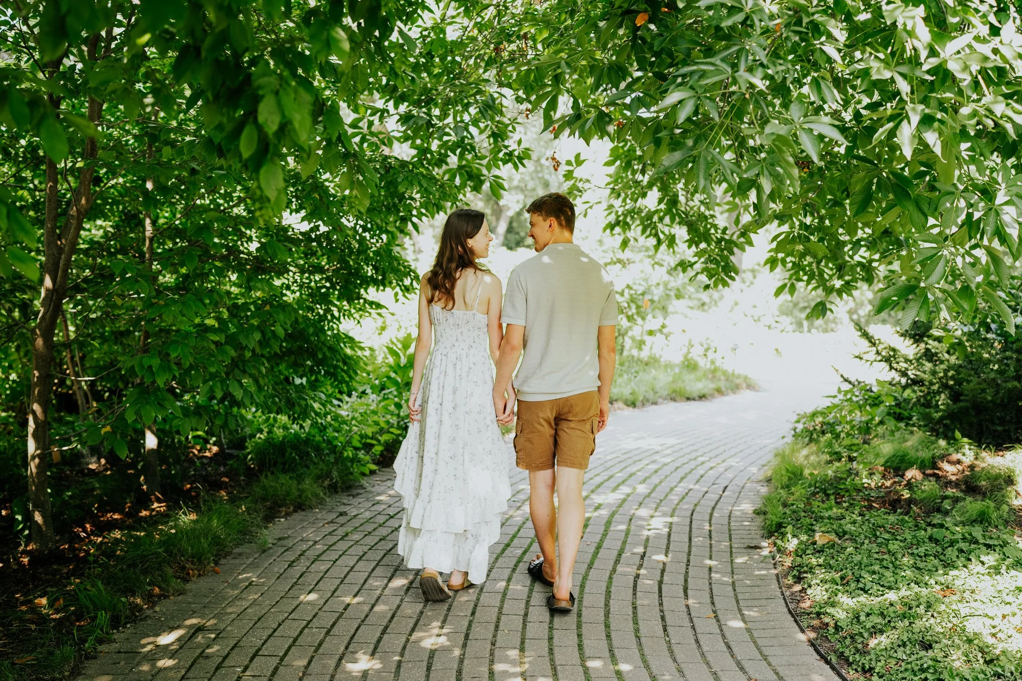 Newly engaged couple strolling through the gardens together