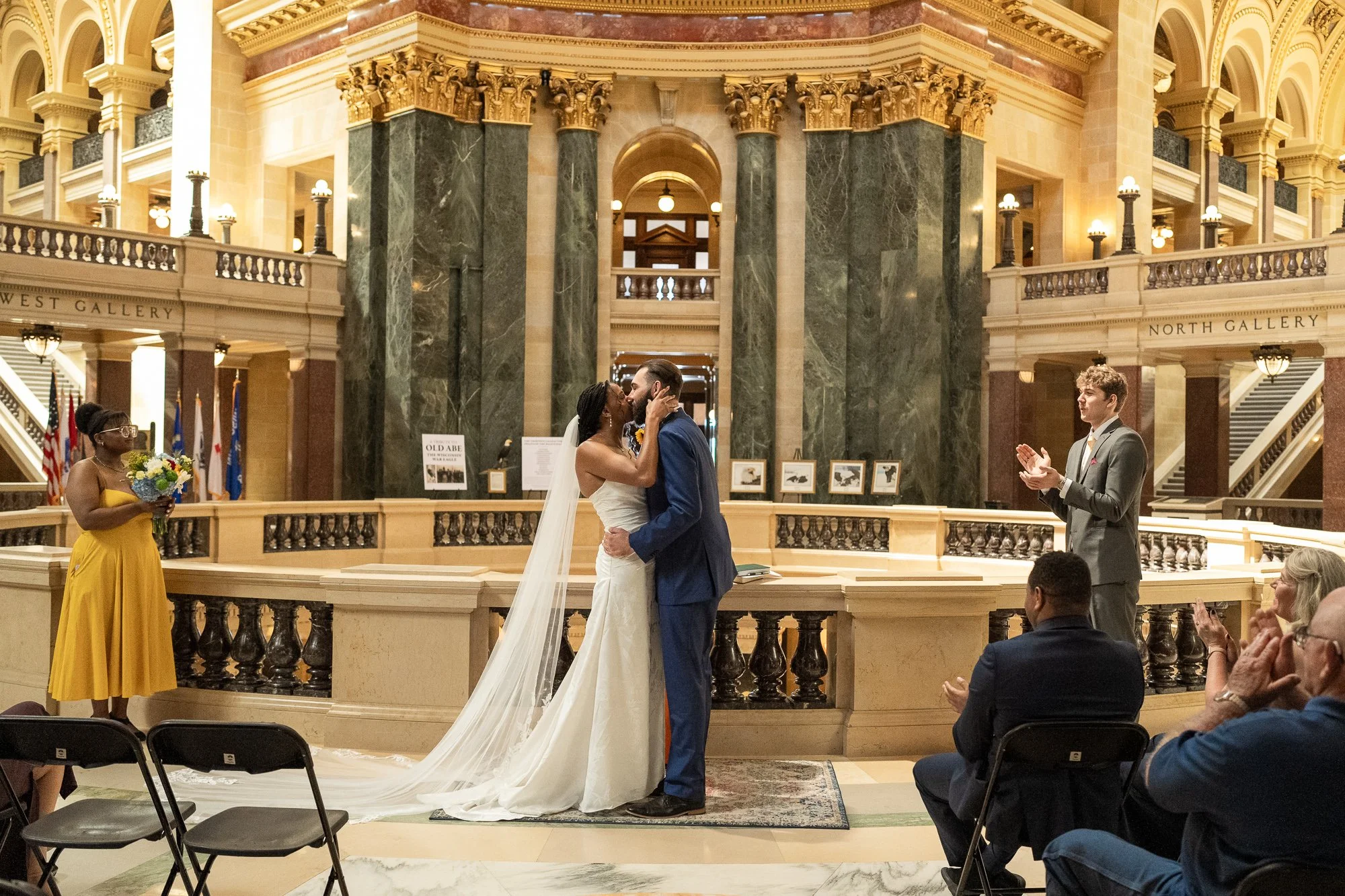 Couple sharing their first kiss during an intimate wedding ceremony inside the Wisconsin State Capitol in Madison.