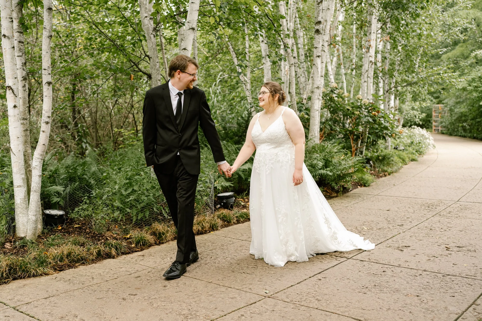 Bride and groom walking through Olbrich Botanical Gardens after their elopement