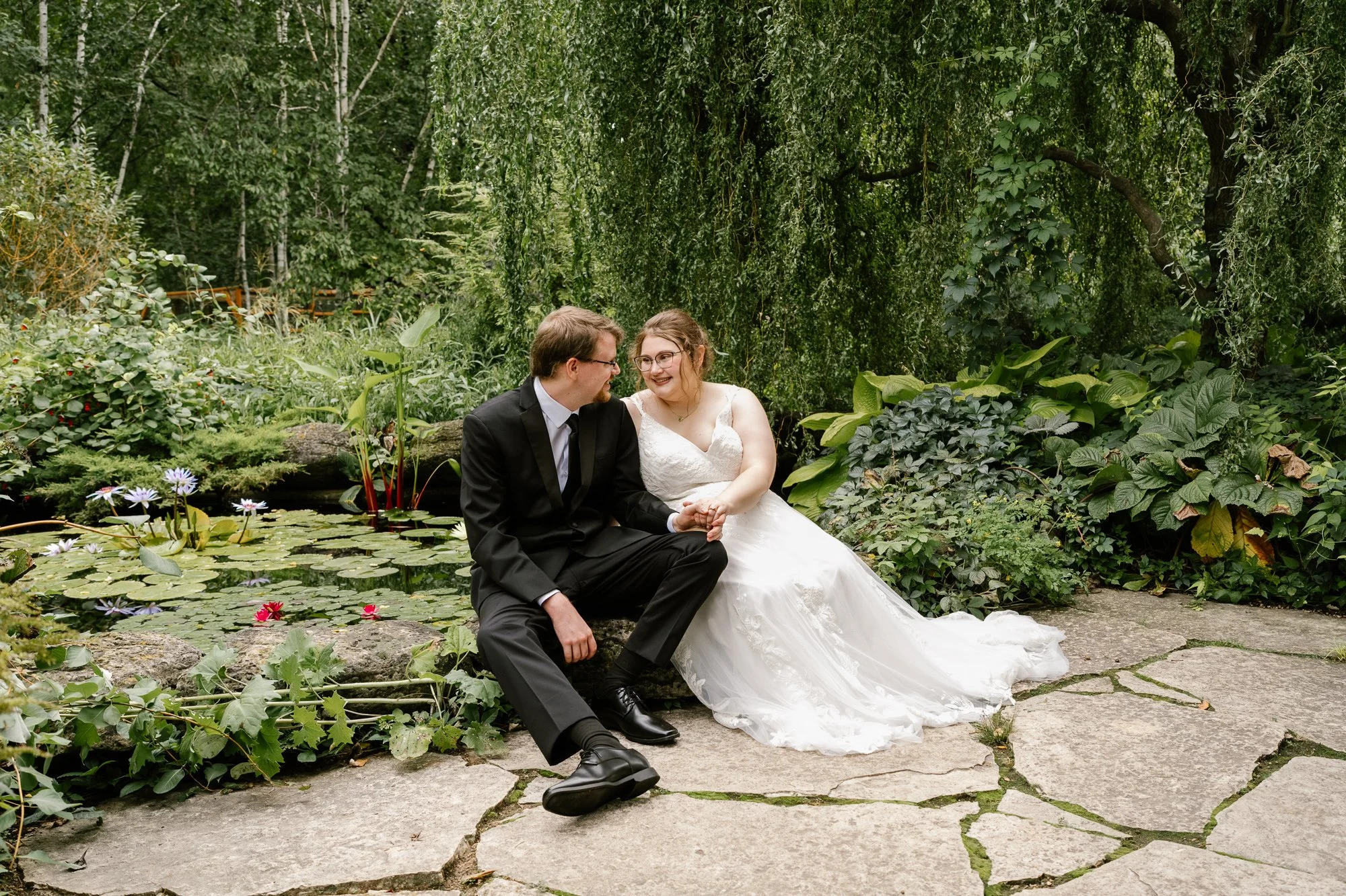 Bride and groom beside the pond at Olbrich Botanical Gardens in Madison