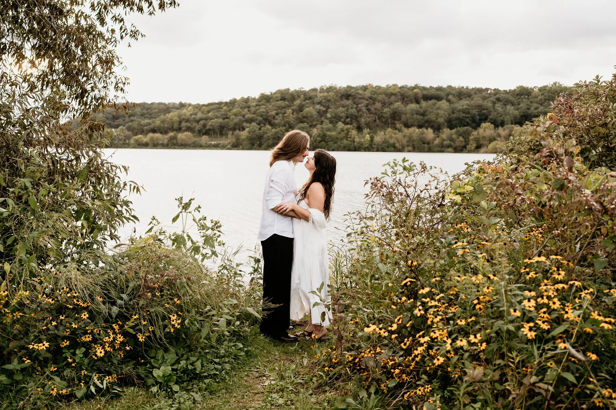 Couple embracing among wildflowers beside the lake at Indian Lake County Park near Madison, Wisconsin.