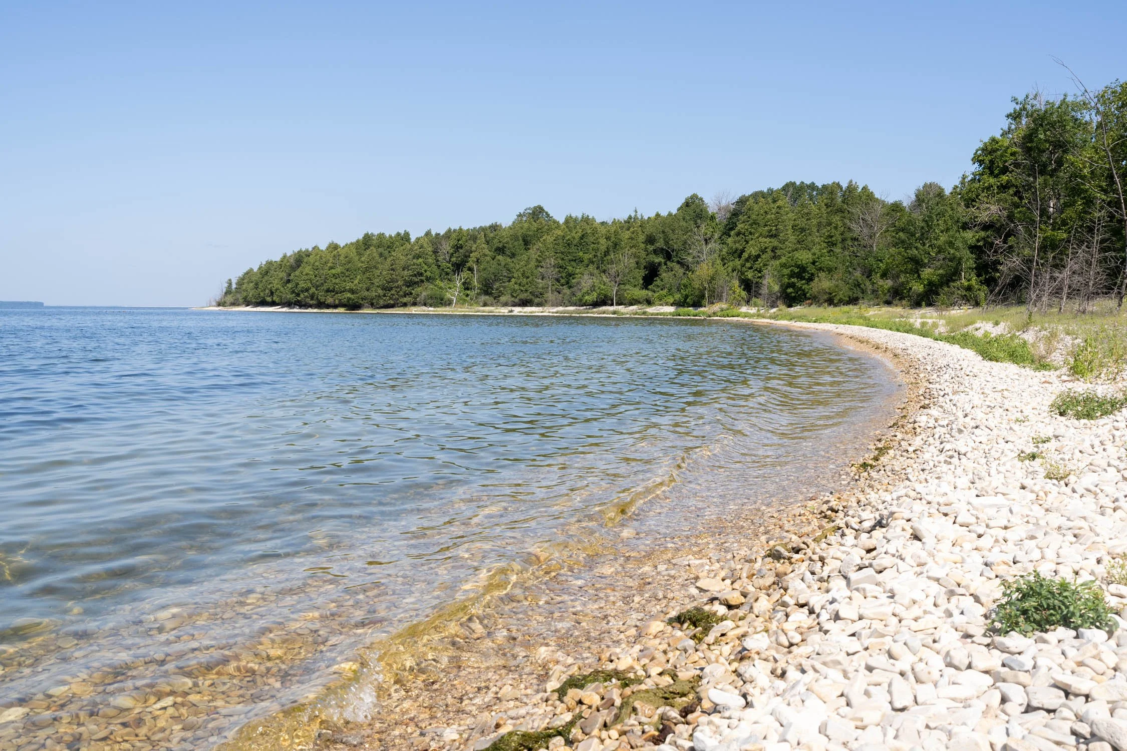 The shoreline at peninsula state park featuring white rocks on a sunny day.