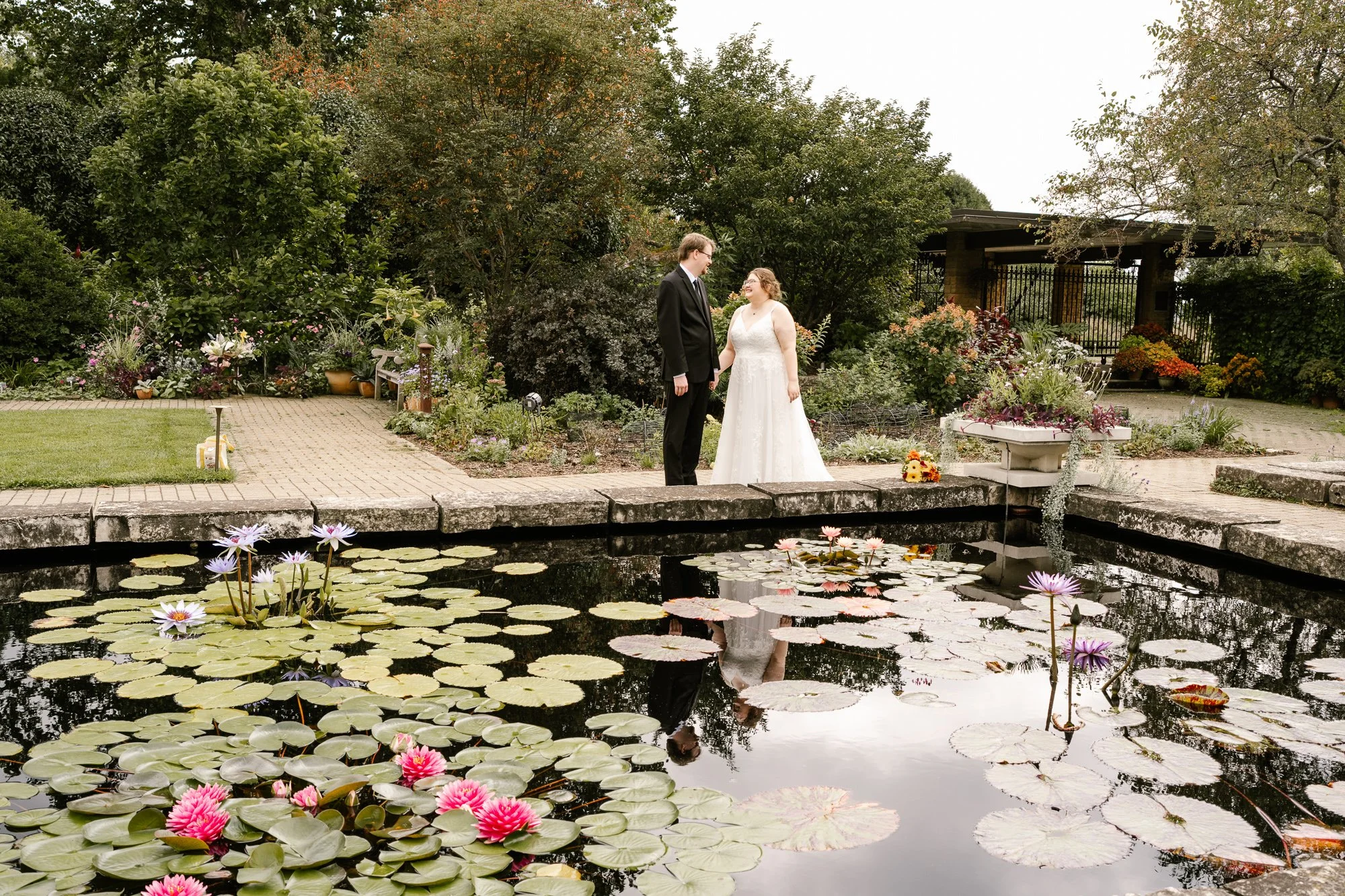 Bride and groom beside the water lily pond at Olbrich Botanical Gardens in Madison, Wisconsin