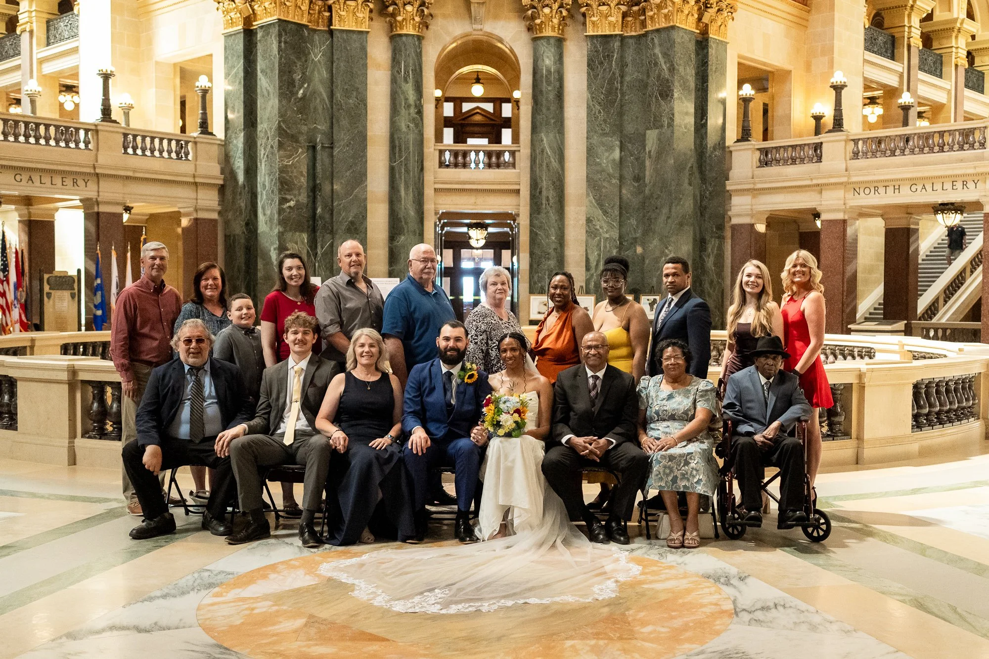 Couple with family and loved ones after their intimate wedding ceremony inside the Wisconsin State Capitol in Madison.
