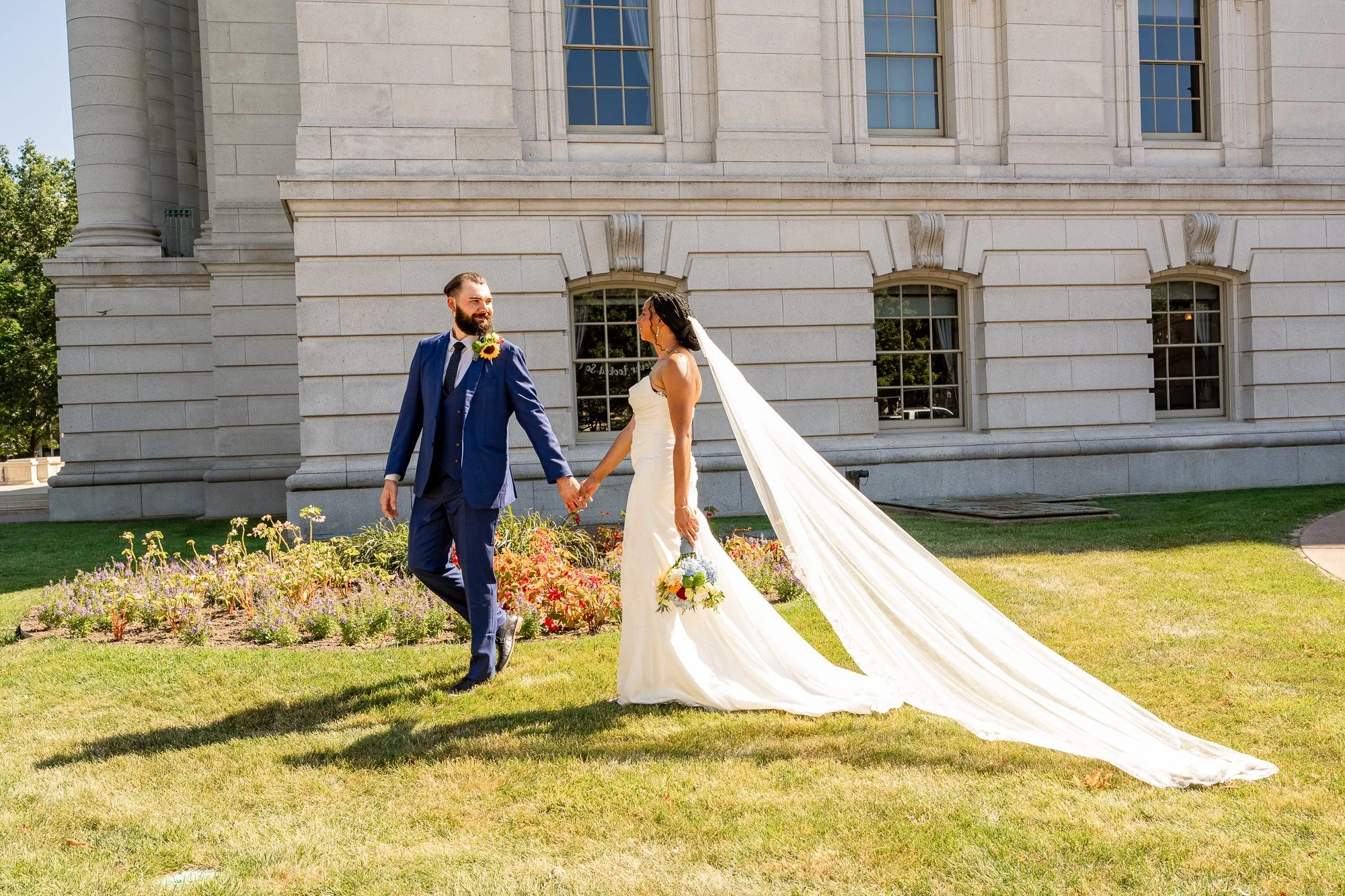 Newlywed couple walking hand in hand outside the Wisconsin State Capitol during their Madison elopement.