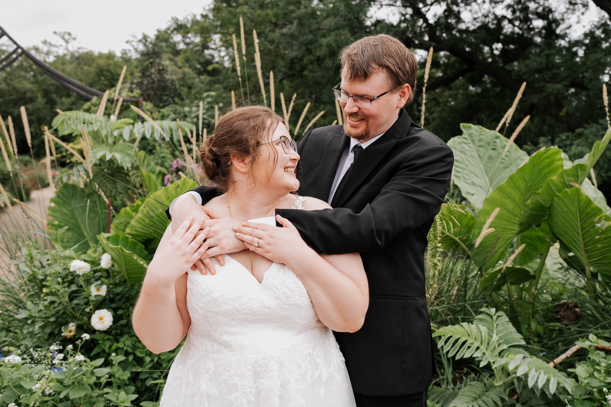 Newlywed portrait surrounded by late-summer flowers and greenery in Madison