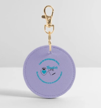 Lavender-colored round keychain with 'Teacher Life' design.