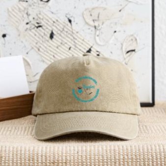 Beige baseball cap with a blue embroidered logo on the front, placed on a woven surface.