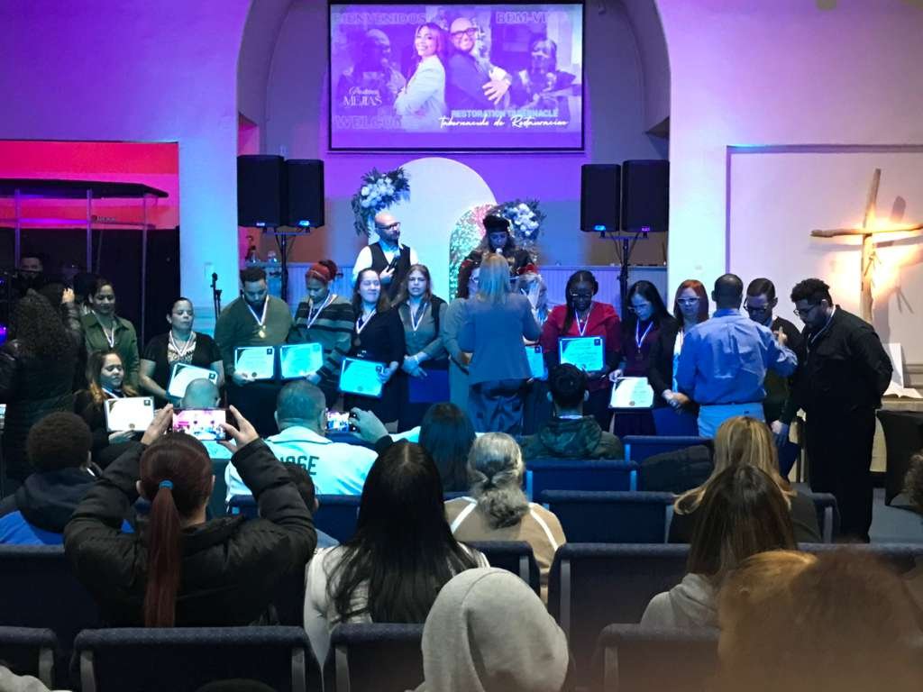 Orando y ungiendo al primer grupo graduado de la Academia Teológica.