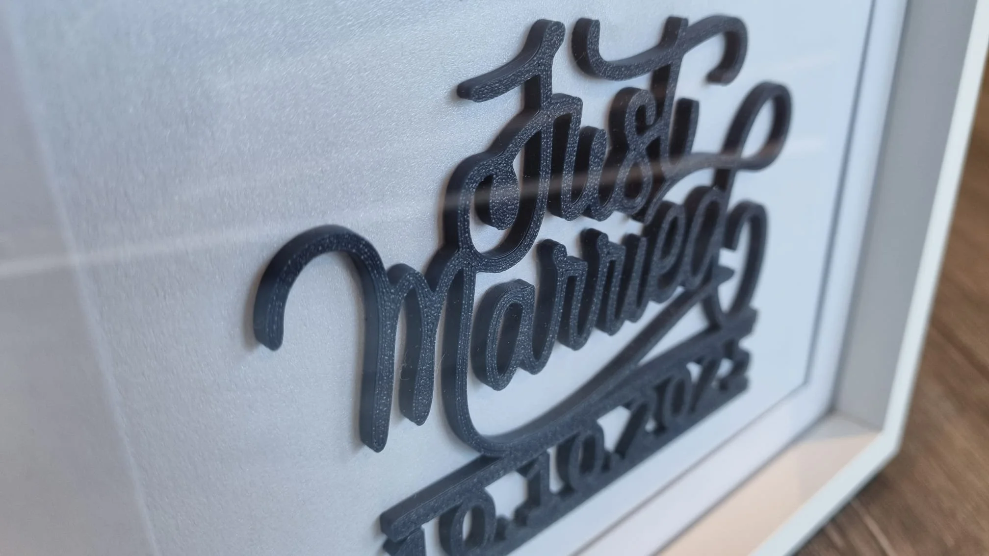 Close-up of a decorative sign with raised, black, cursive lettering reading 'Thankful' mounted on a light-colored wall.
