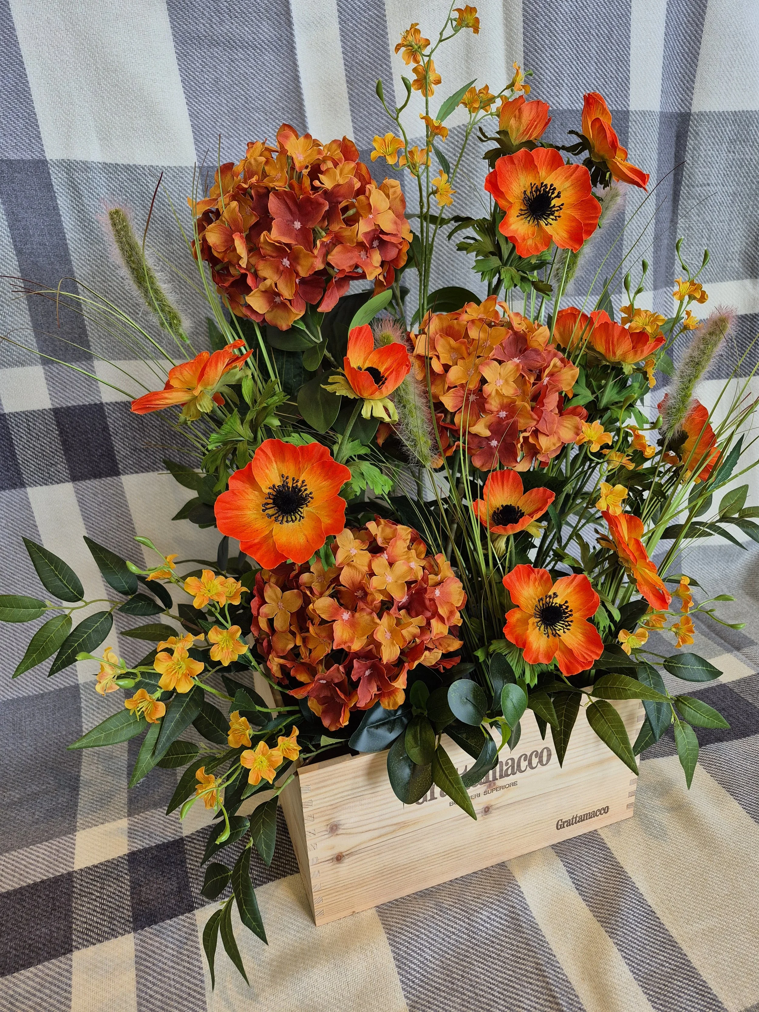 Bright and burnt orange floral floor display in a vintage wine box for weddings and events
