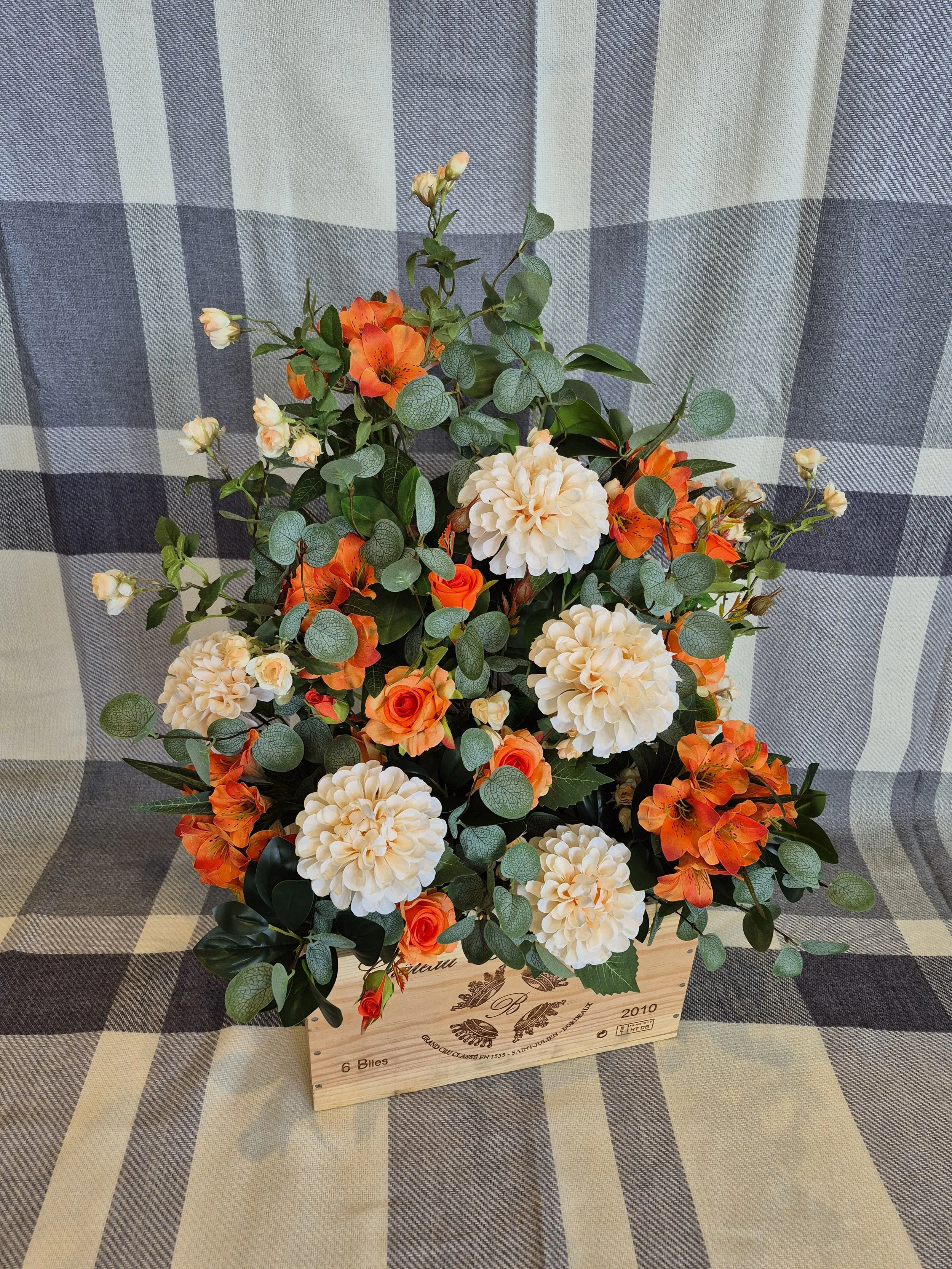 orange and peach floor display in an autumn theme displayed in a vintage wine box