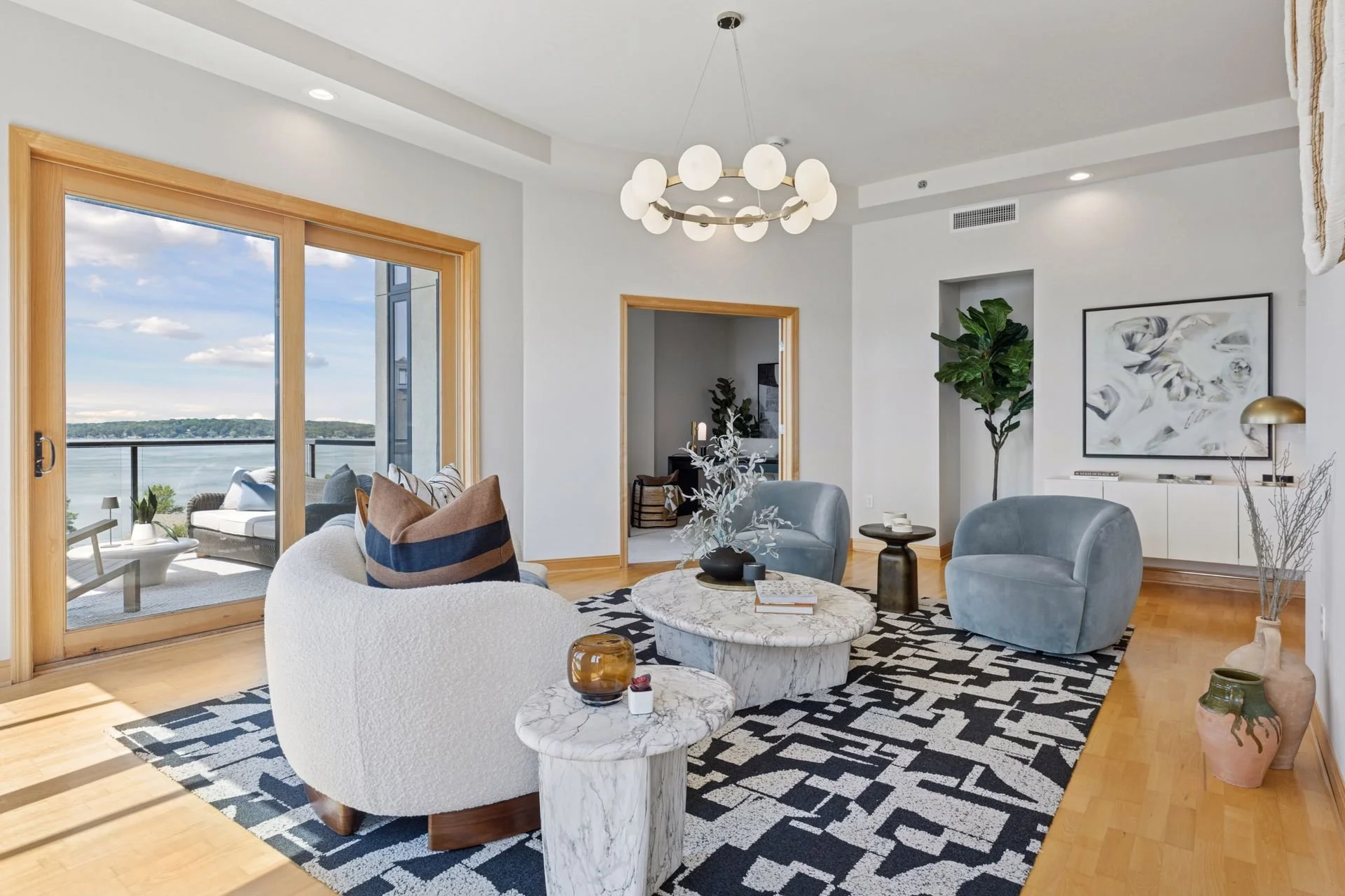 Modern living room with large sliding glass doors leading to a balcony overlooking Lake Minnetonka.