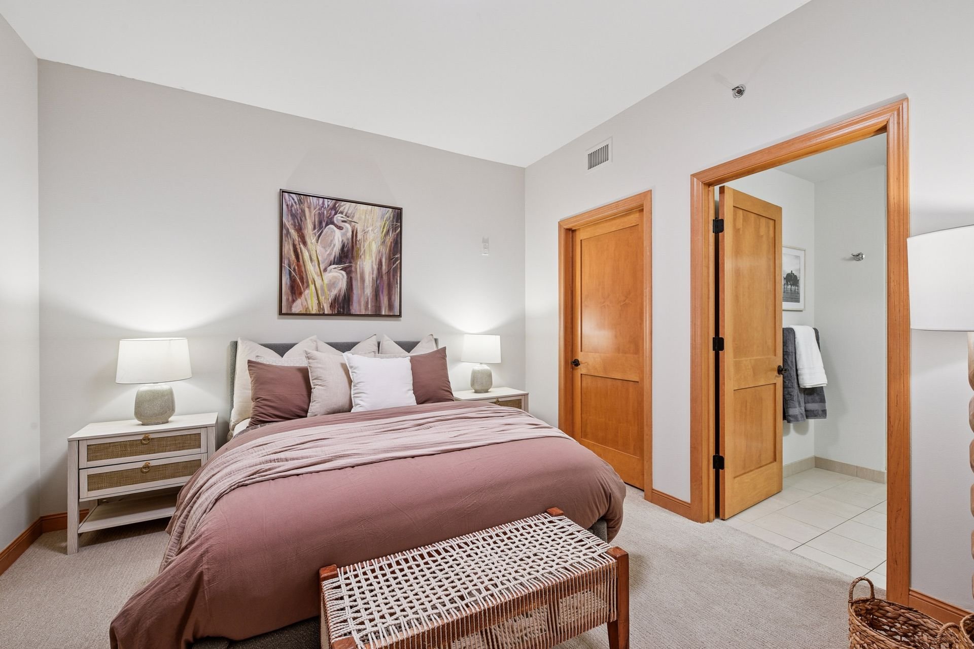 A bedroom and an open door leading to a bathroom.