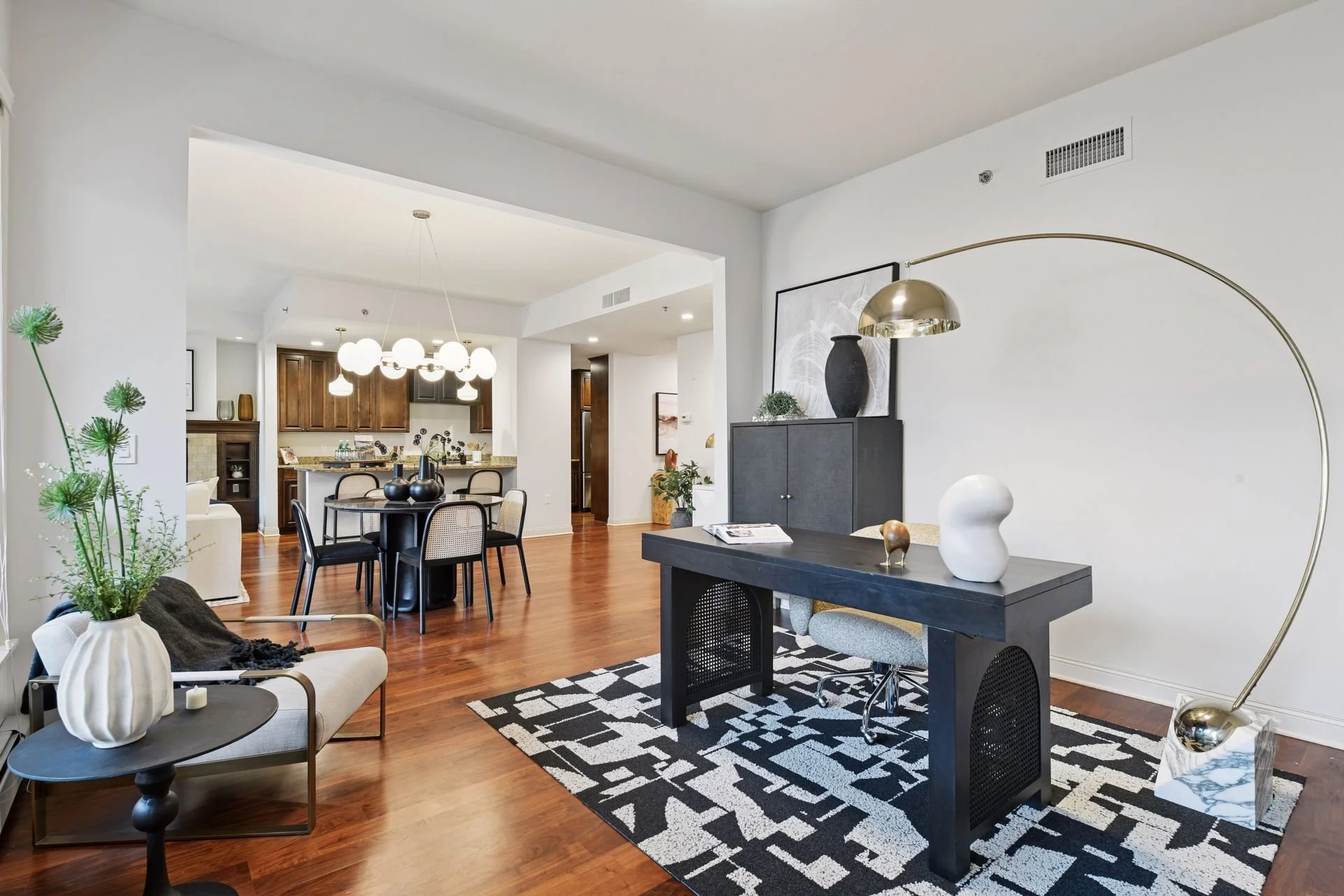 Living and dining room with white walls and wooden floors.