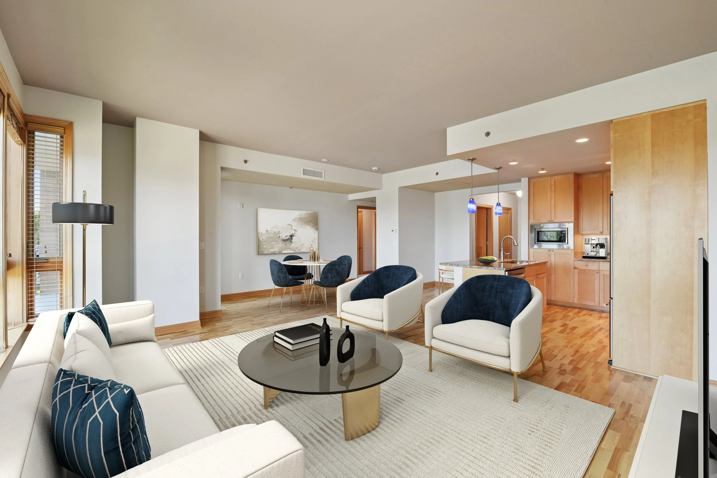 Modern living room with hardwood flooring, large windows with blinds, adjacent dining area, kitchen with wooden cabinets, granite island, and stainless steel appliances.
