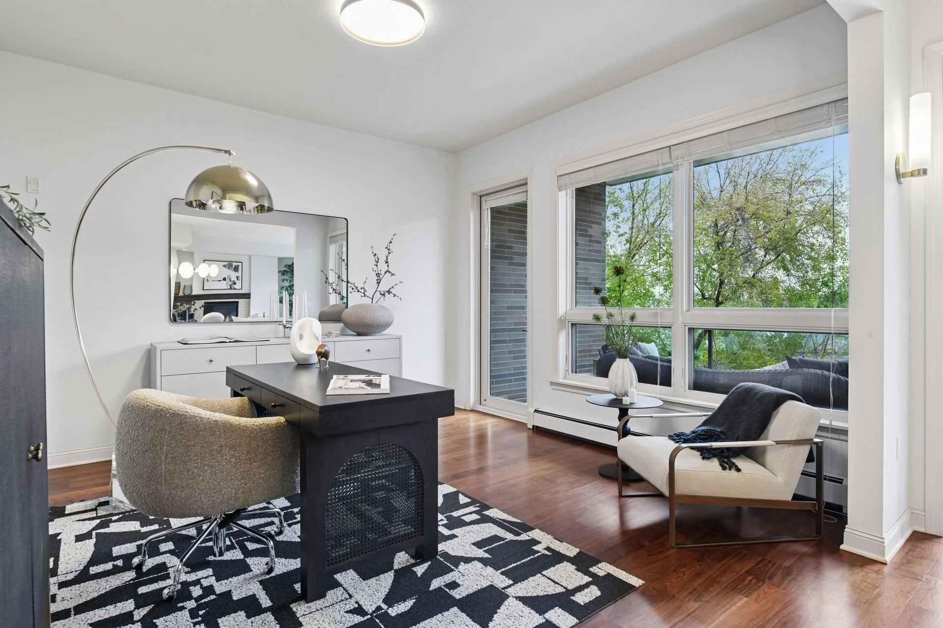 Living room with large windows, and wooden flooring.