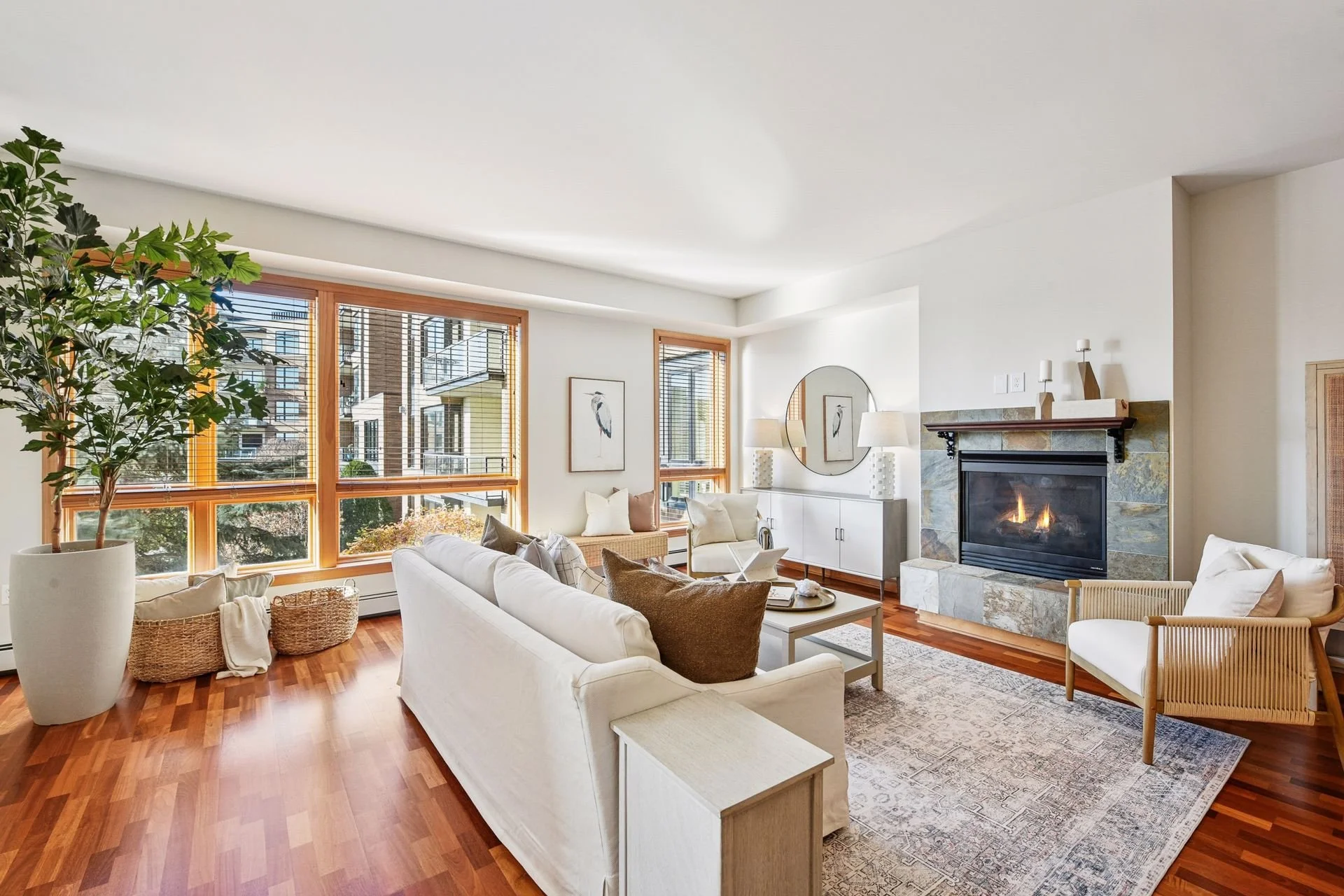 Bright living room with large windows and a fireplace.