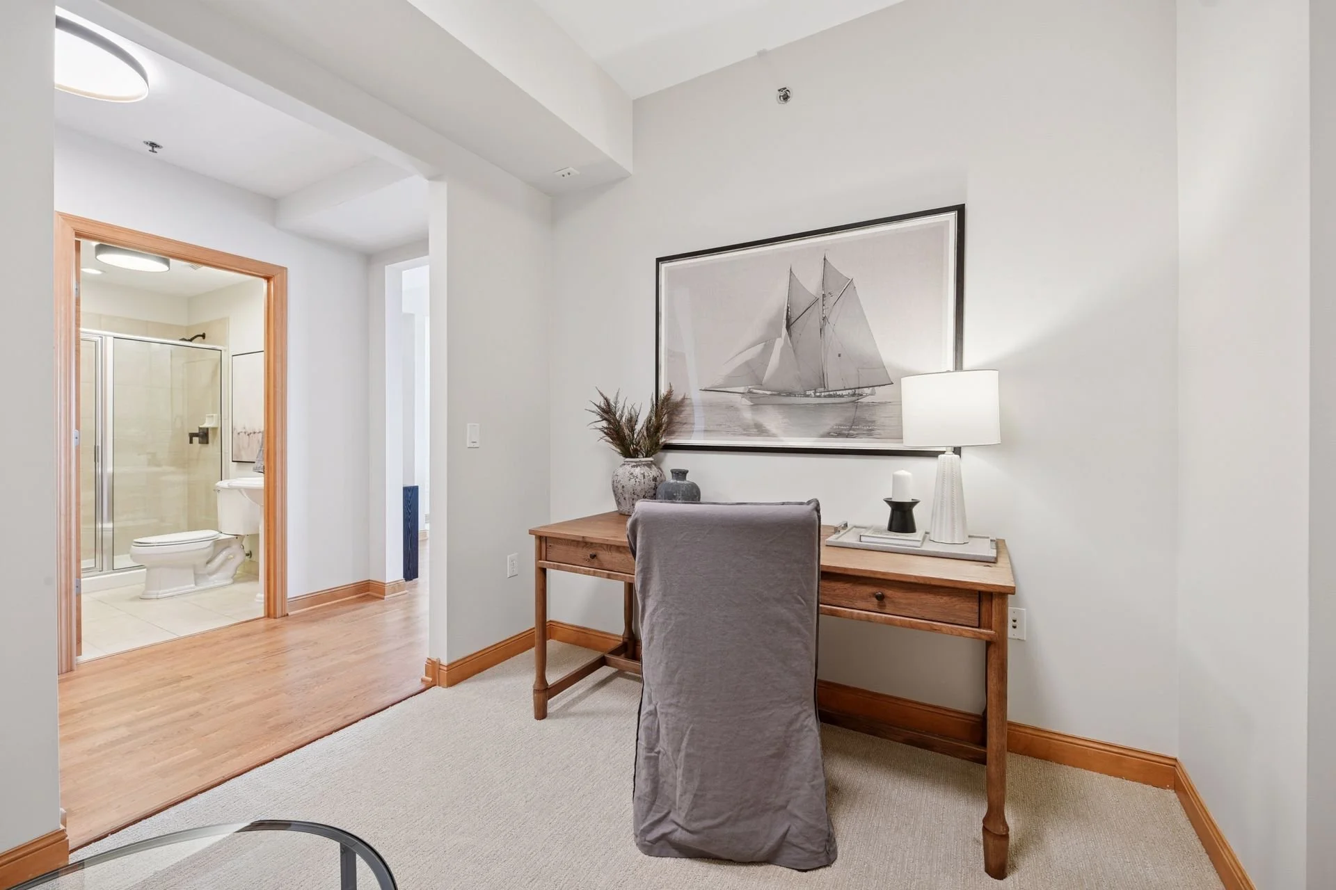 Home office with an adjacent bathroom with shower visible in the background.