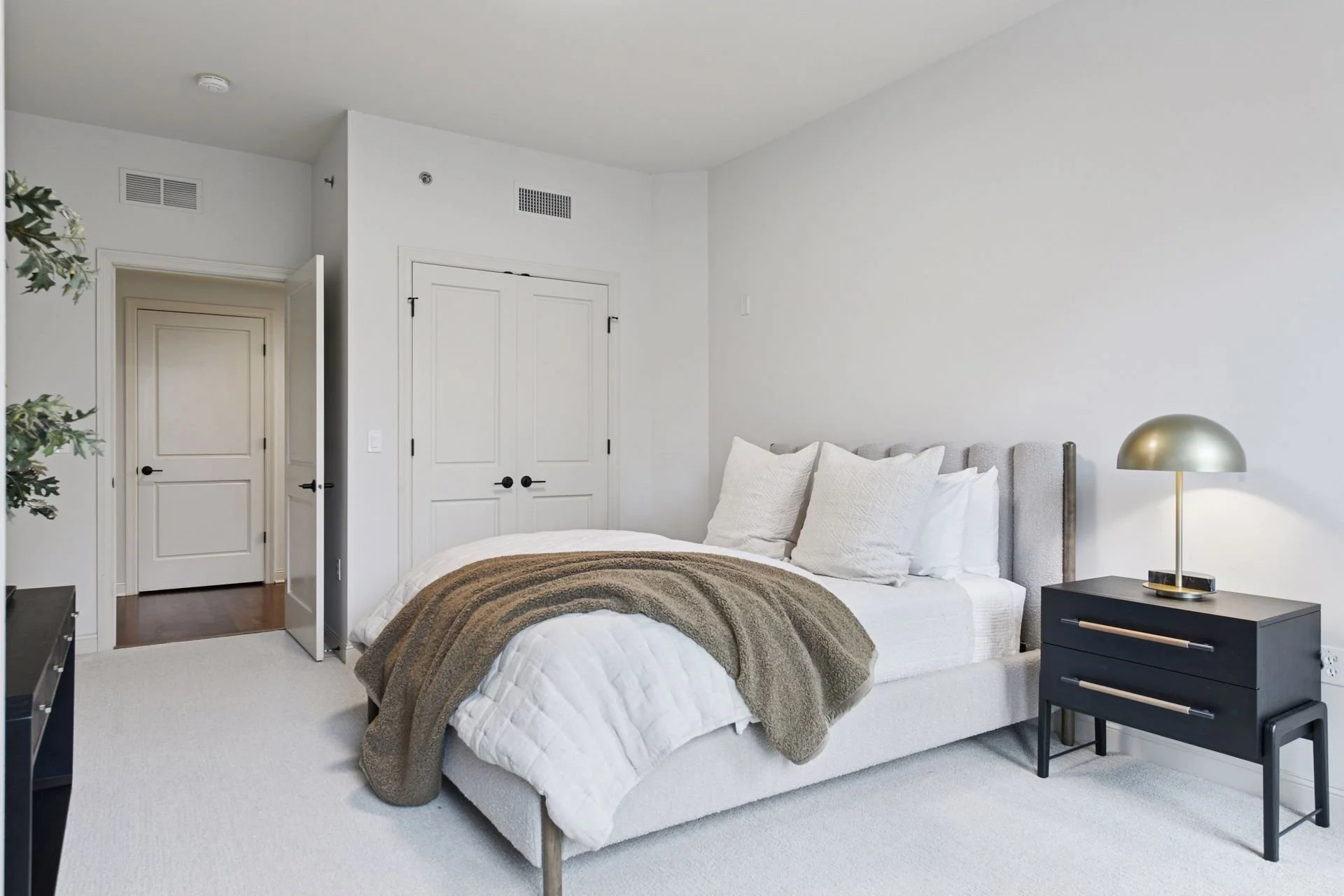 Modern bedroom with a closet with double doors.