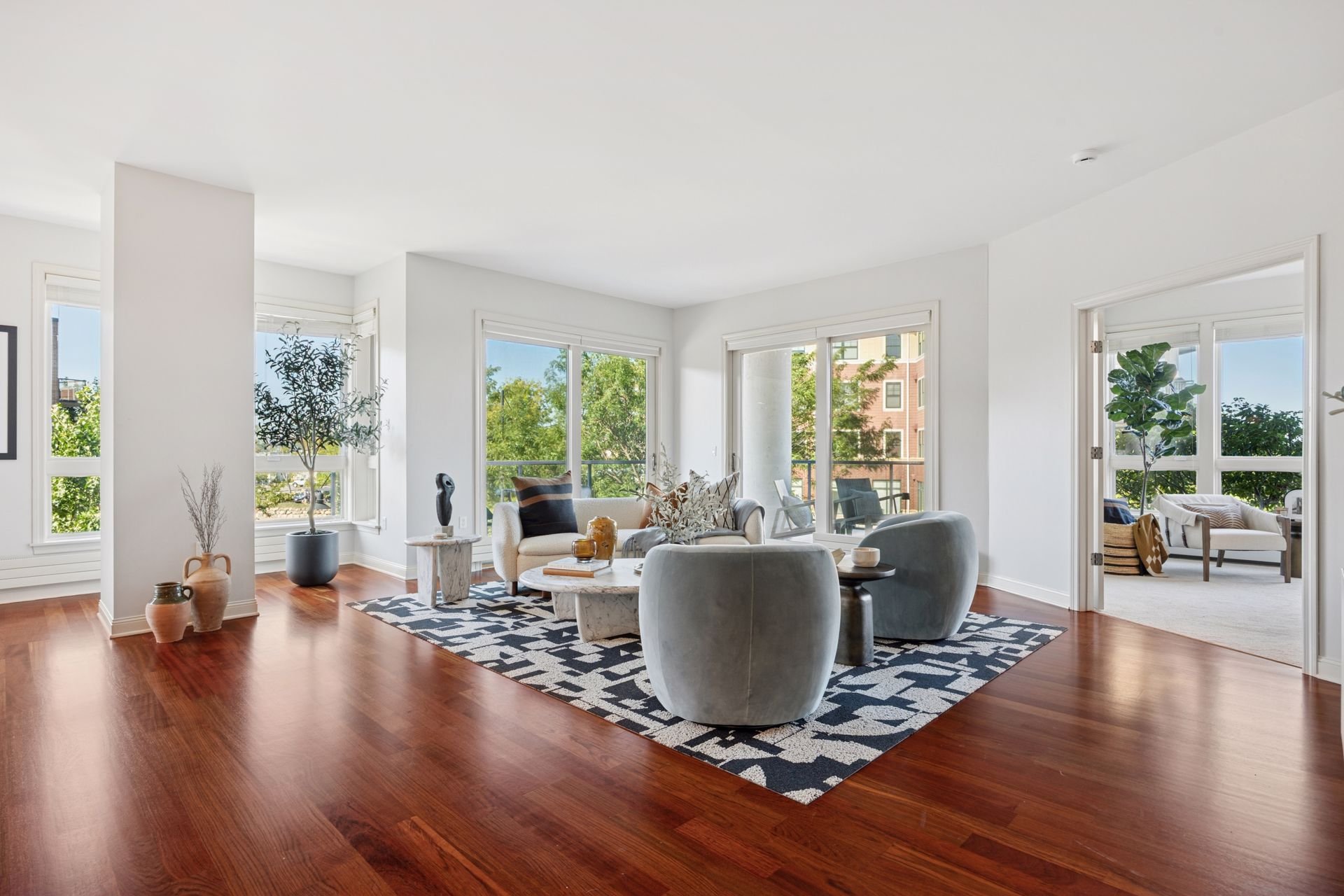 Bright living room with large windows and wooden floors.