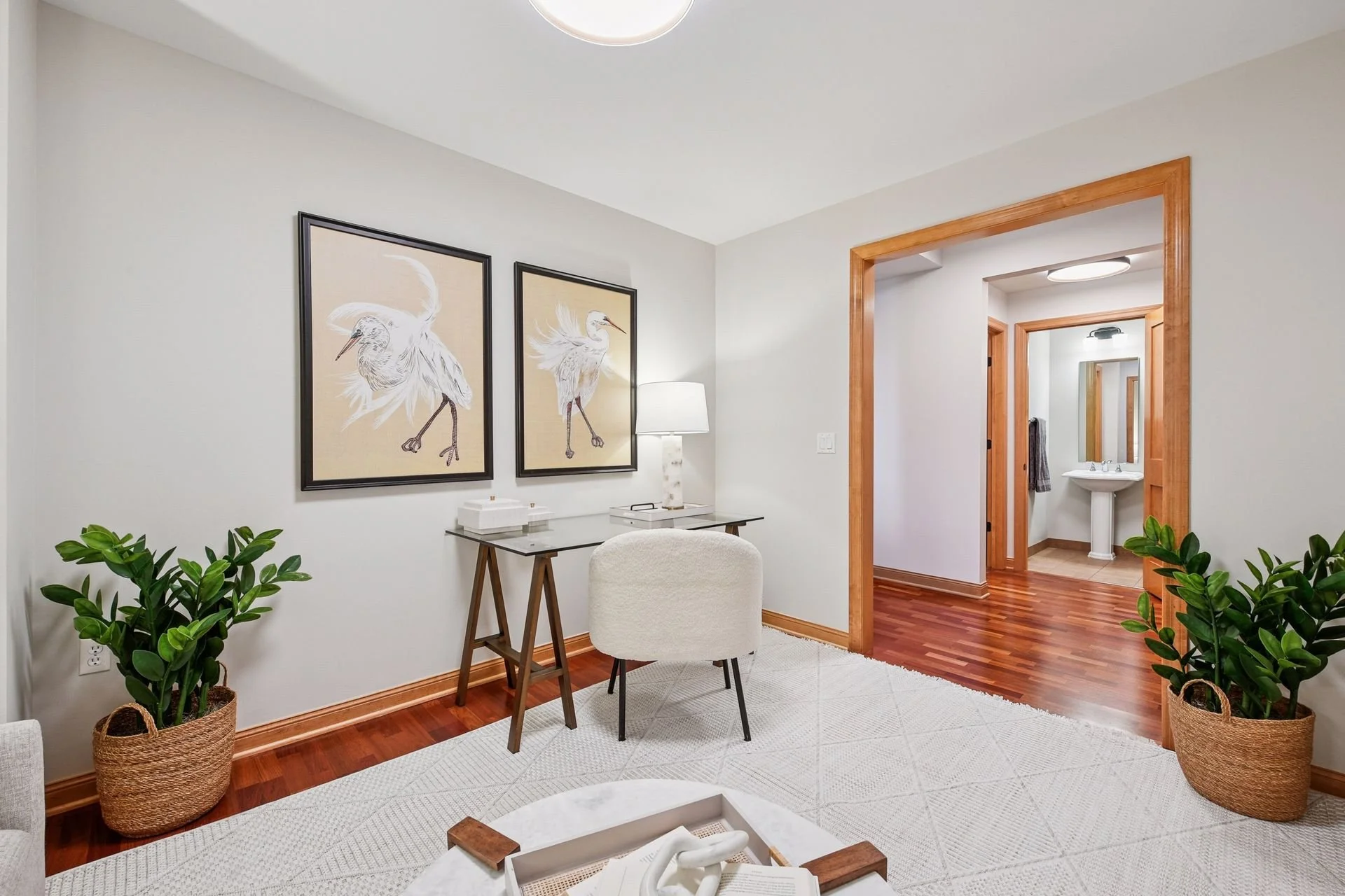A cozy room with wooden flooring and white walls.