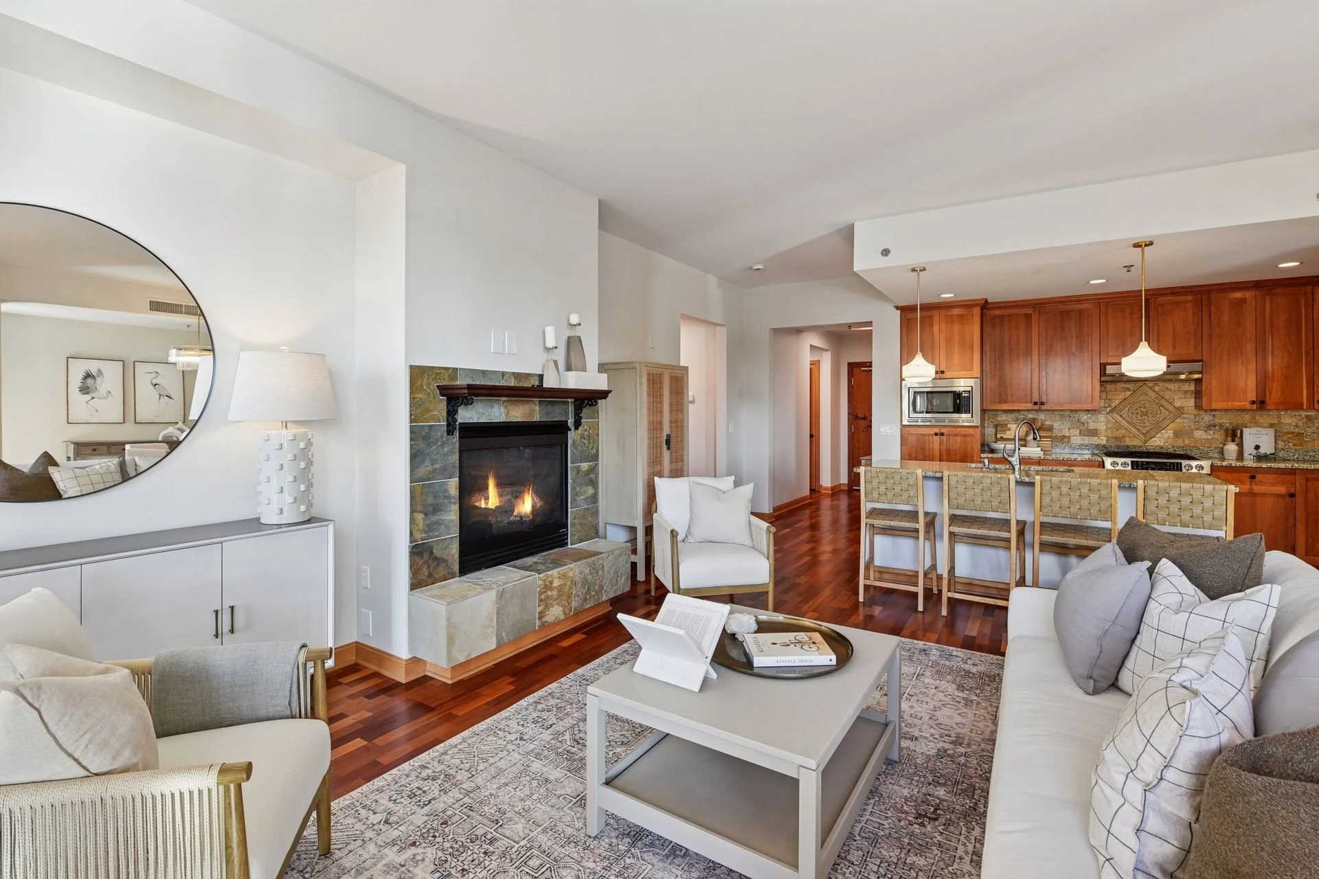 Living room with fireplace, and kitchen with wooden cabinets.