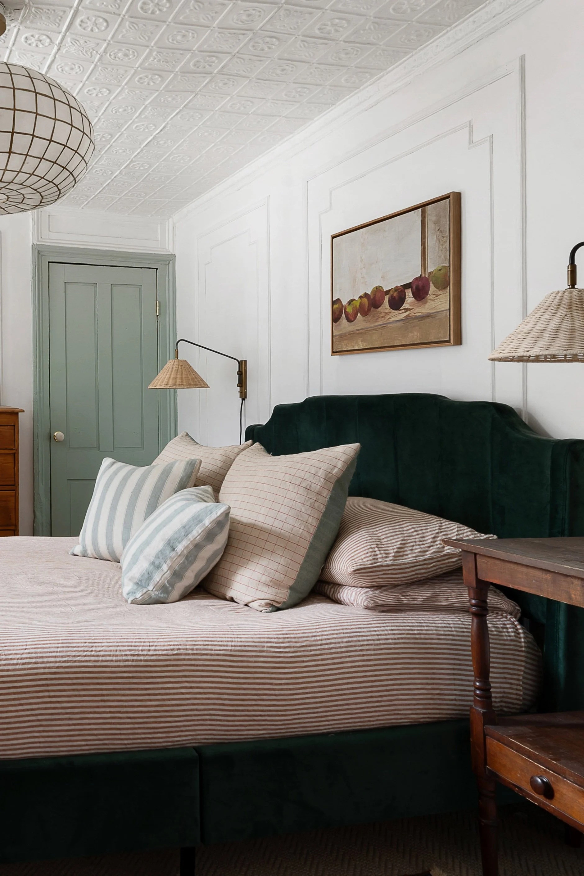 master bedroom with sage green details and velvet green bed headboard