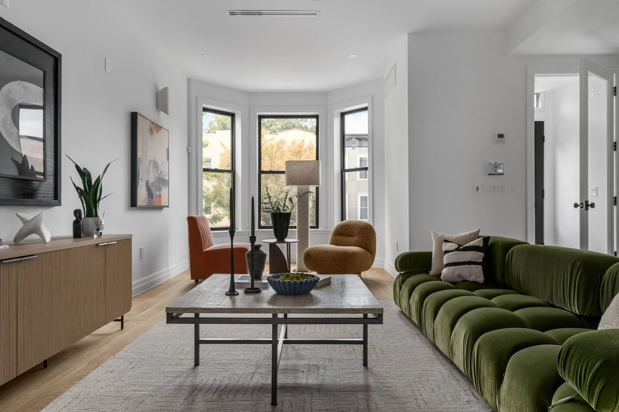 living room area with colorful plush seating and green velvet cloud couch
