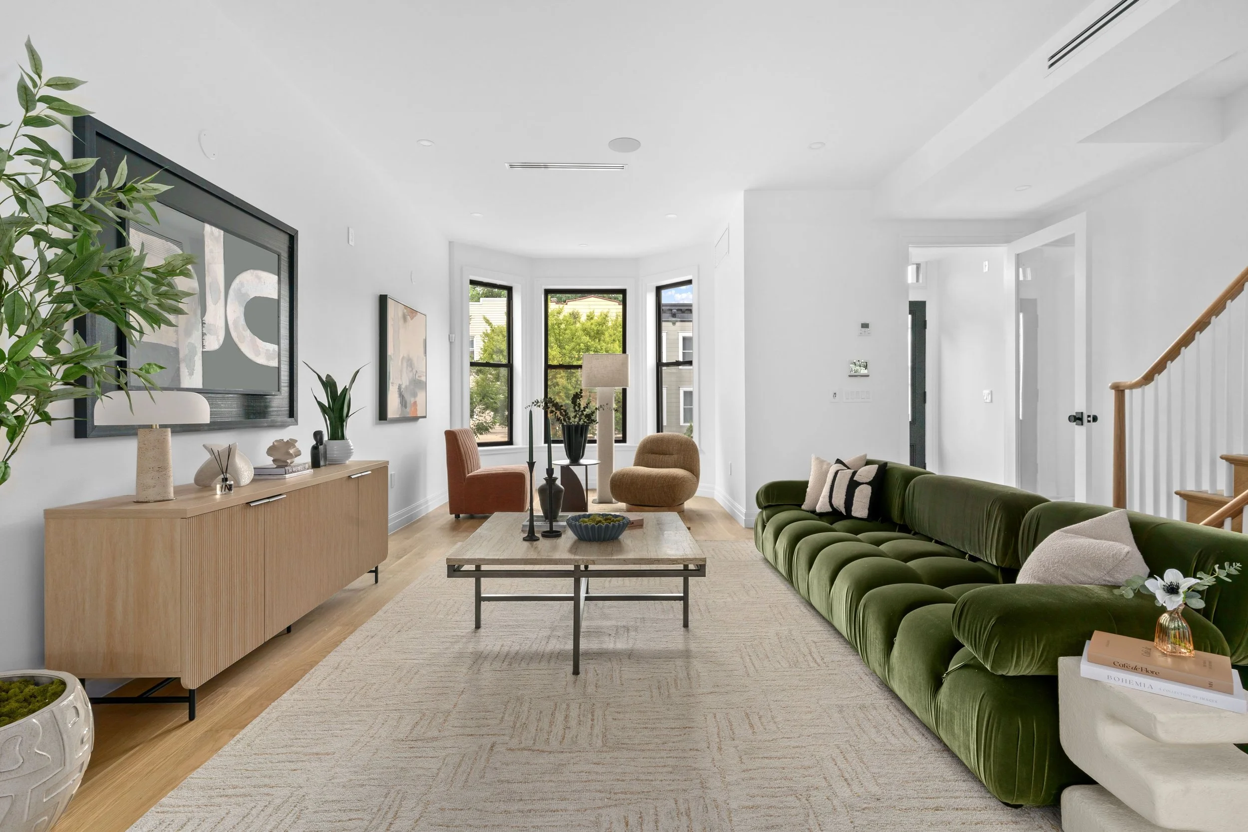 living room with green velvet couch and cozy window nook