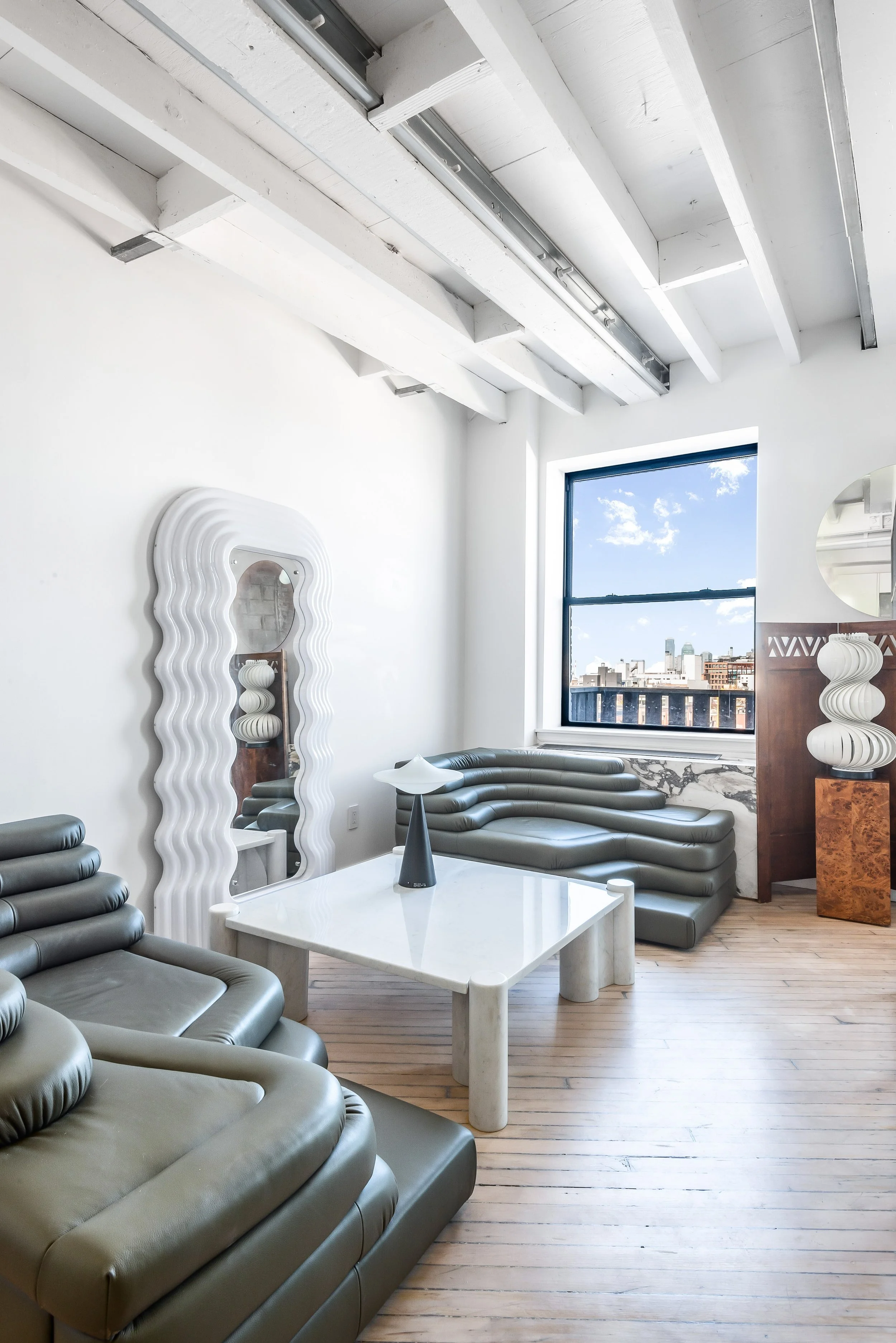 wavy mirror and unique chairs in artsy nyc apartment