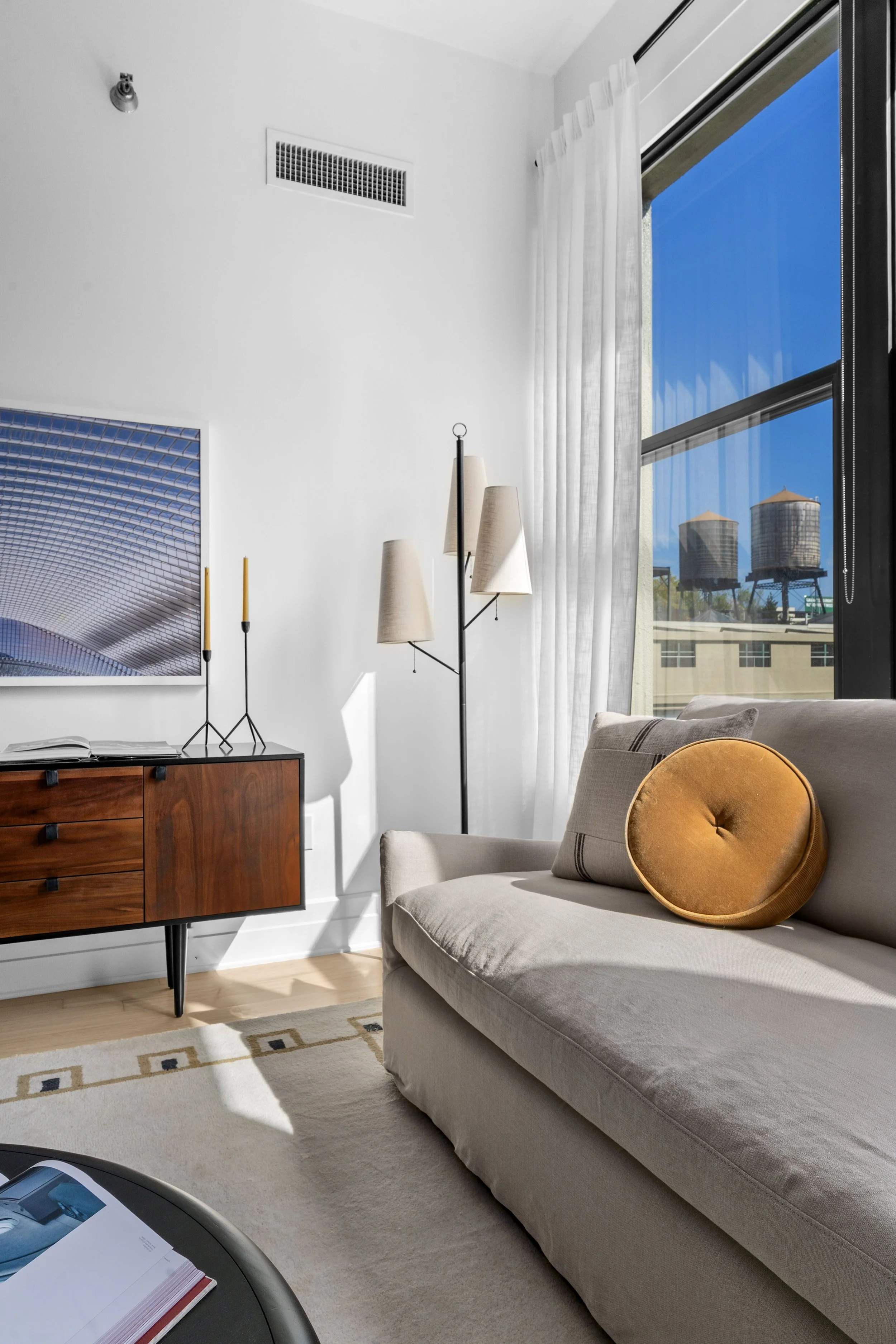 living room details with grey beige couch and mustard yellow throw pillow