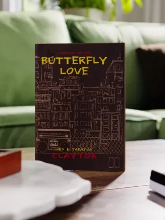 Book titled 'Butterfly Love' by Ken & Tabatha Clayton standing on a table in a living room with a green couch in the background.