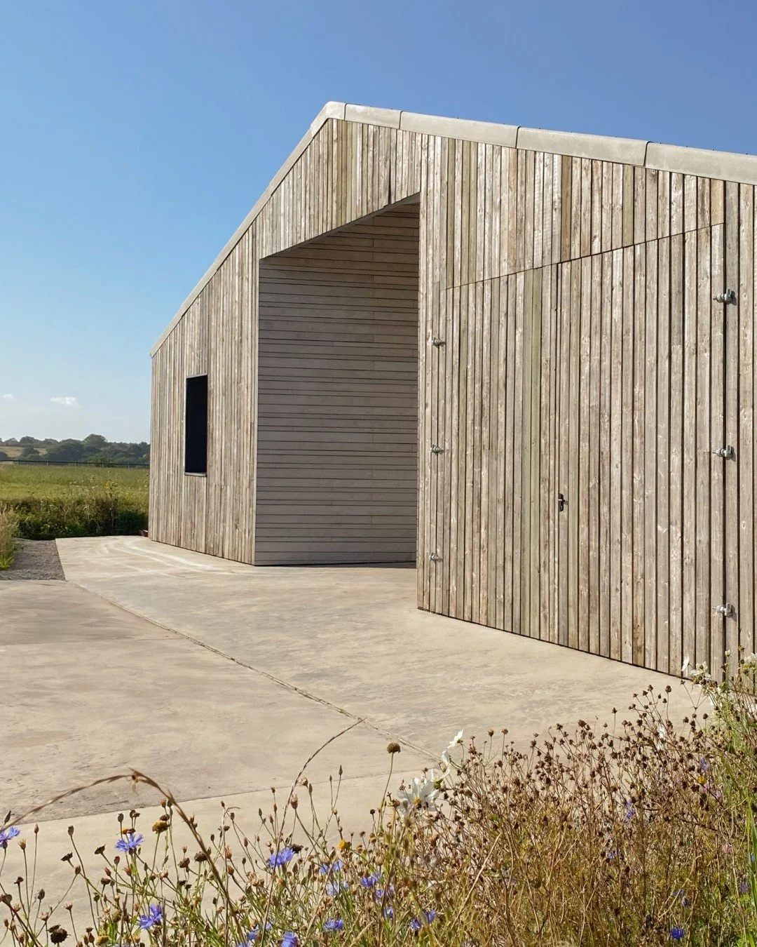 A disused steel-framed agricultural building, a long southerly view across the countryside, and no obvious way to make a house of it.

We kept the barn rather than replacing it with something barn-shaped. Most of the original fabric stayed, including