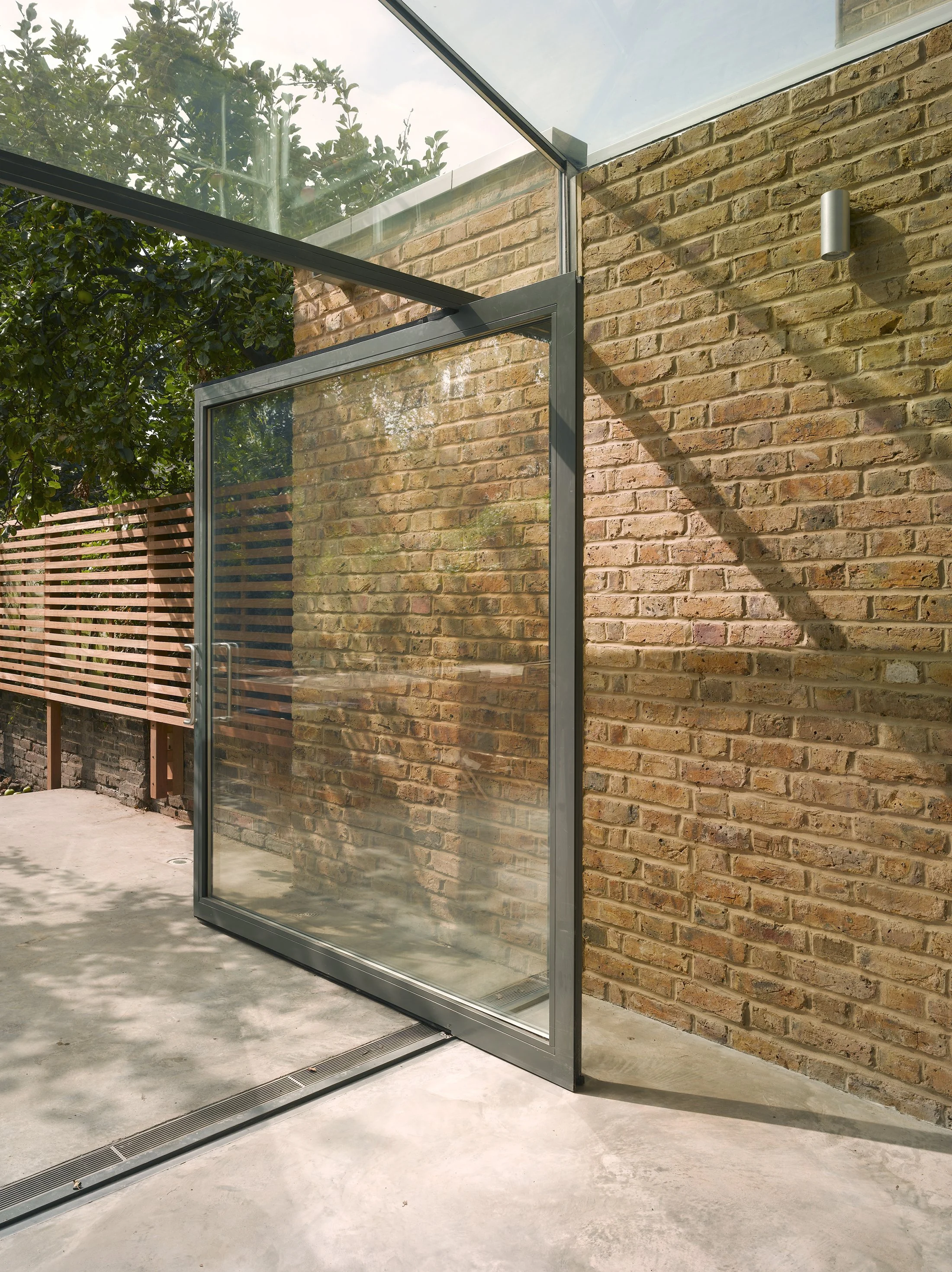 Glass pivot door to garden at Mapledene Road