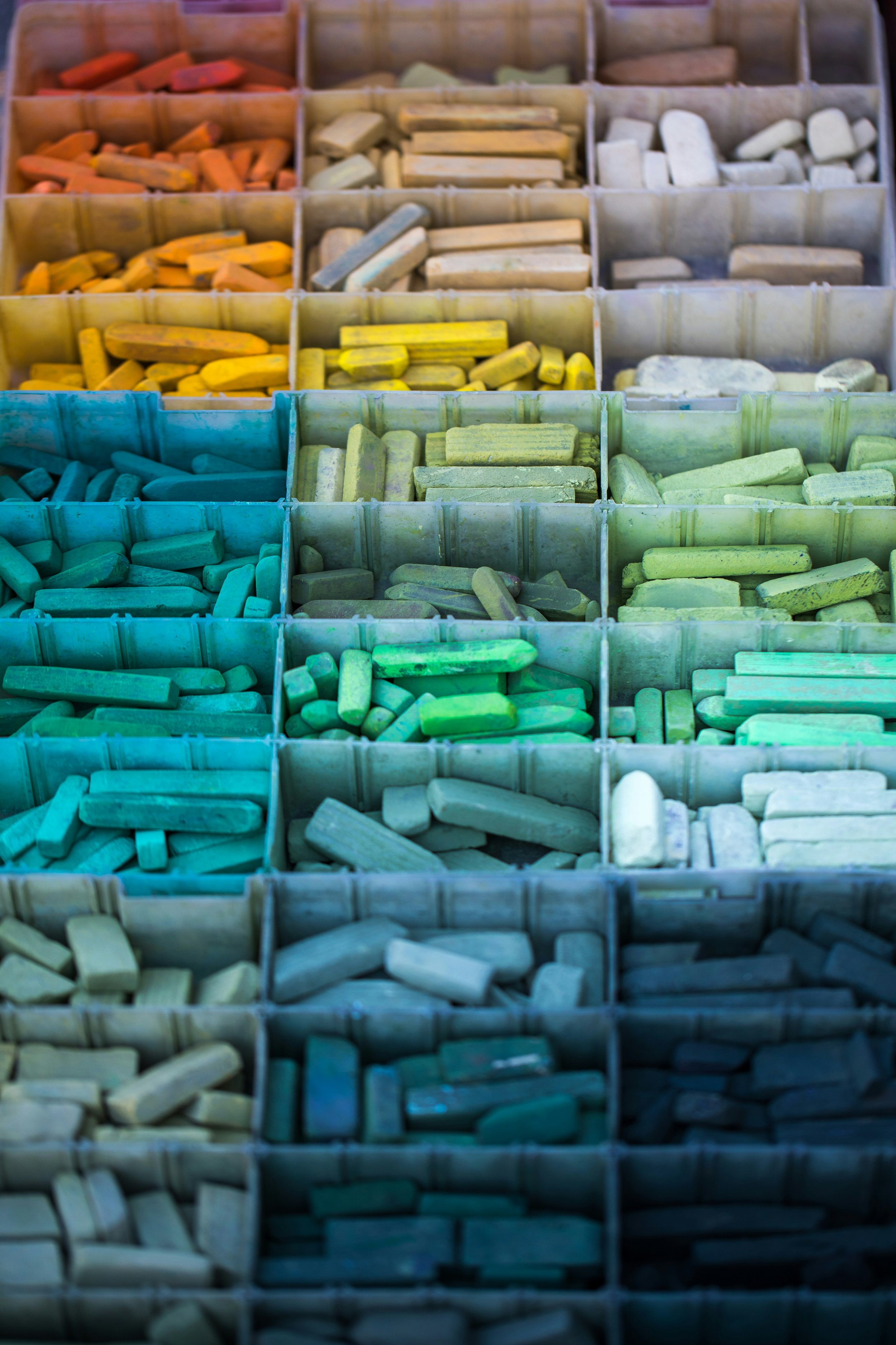 A colorful display of chalk pieces organized by color in separate compartments.