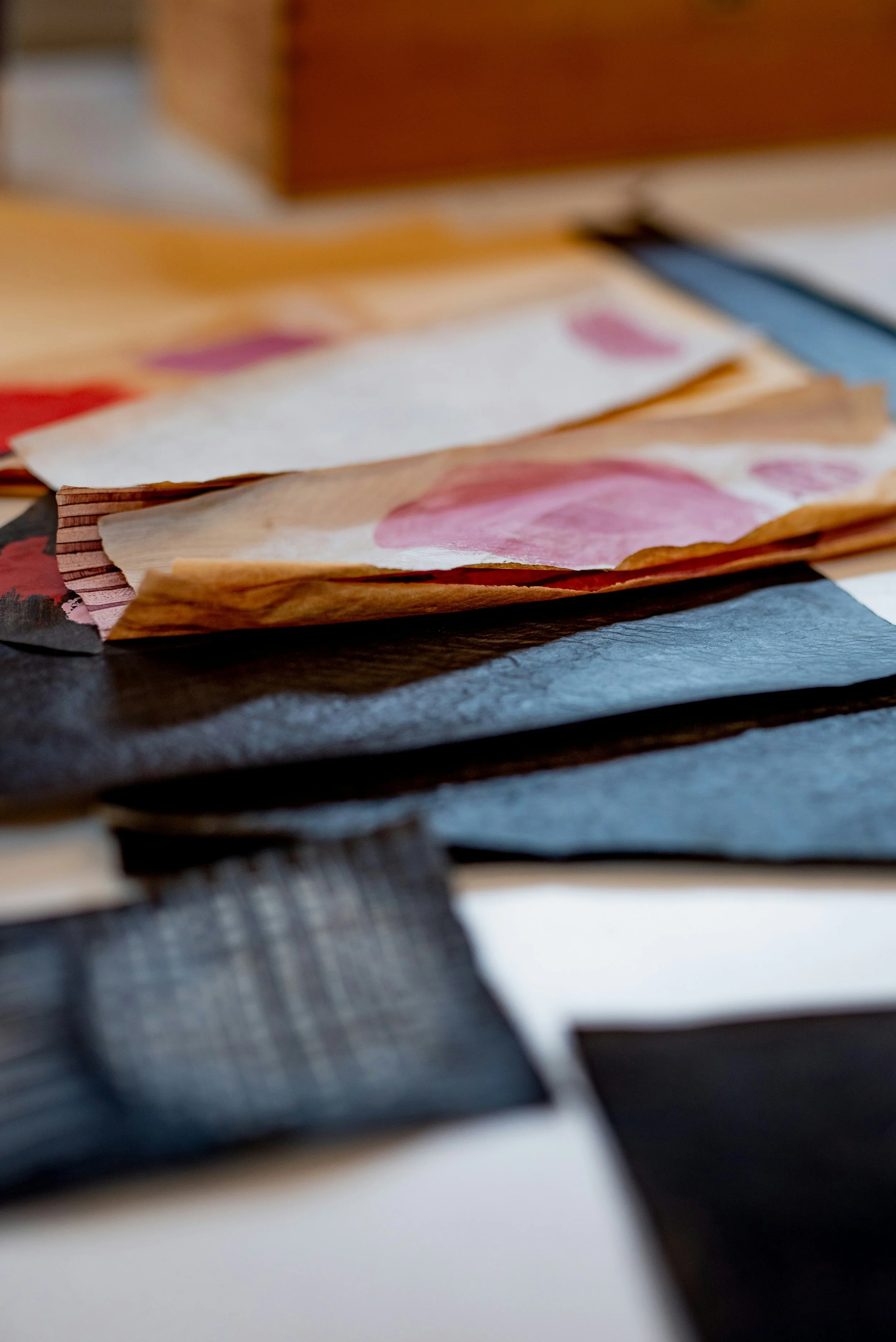 Close-up of crumpled paper with printed pink and red patterns on a table.