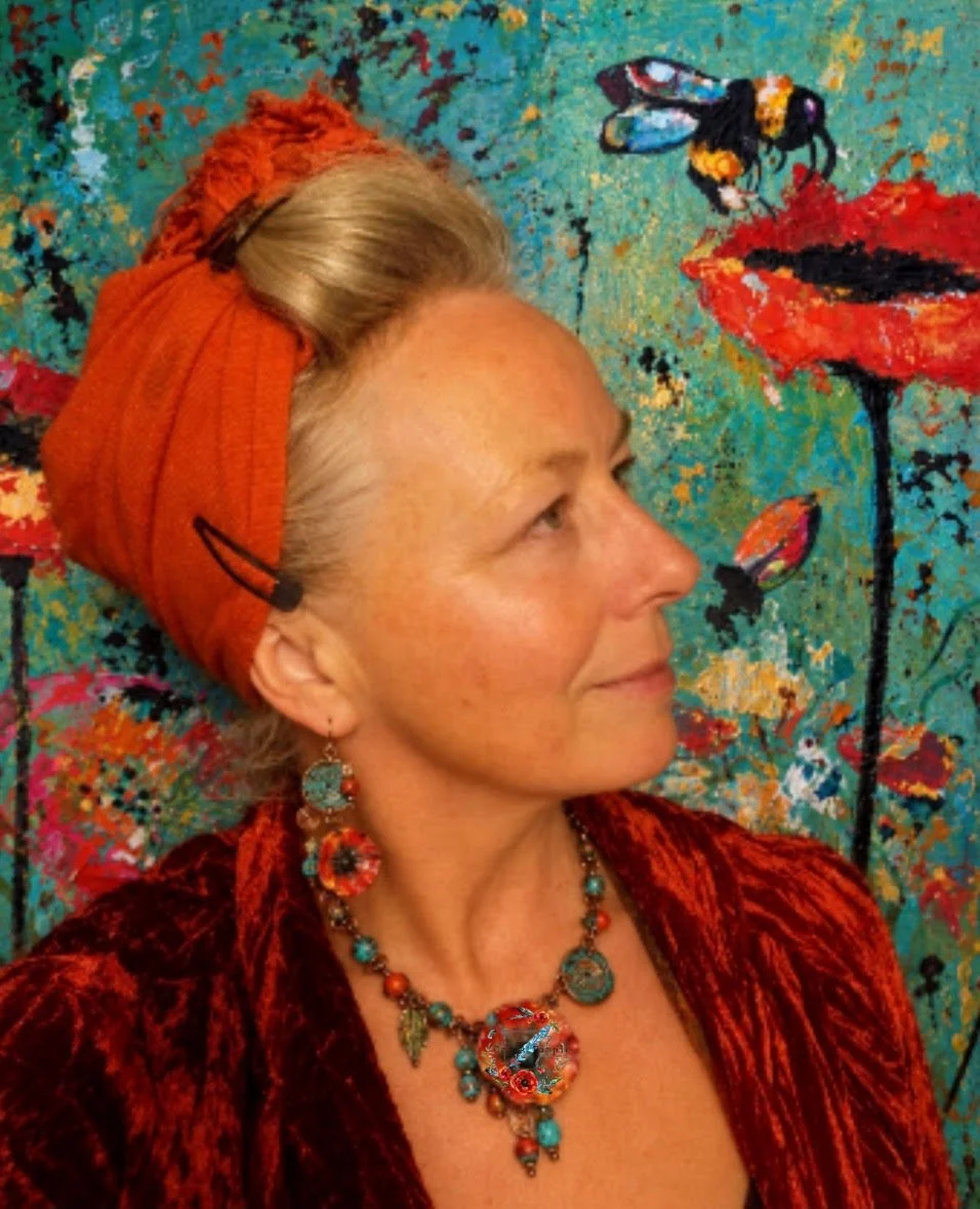 Artist Kim LaPlant, a blonde woman wearing a red headscarf and poppy jewelry