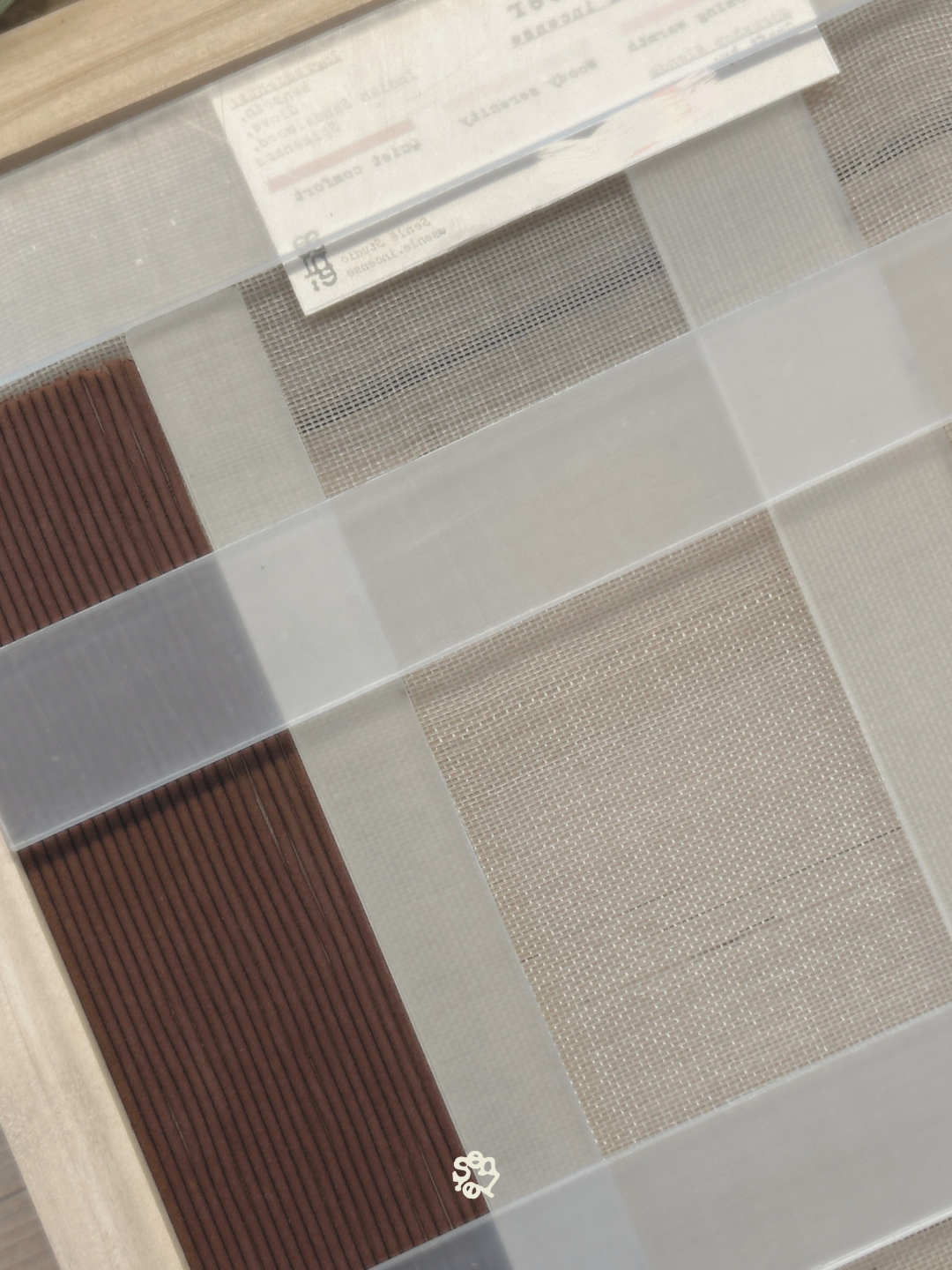 Samples of textured tile or mesh materials in various colors and patterns displayed on a flat surface.