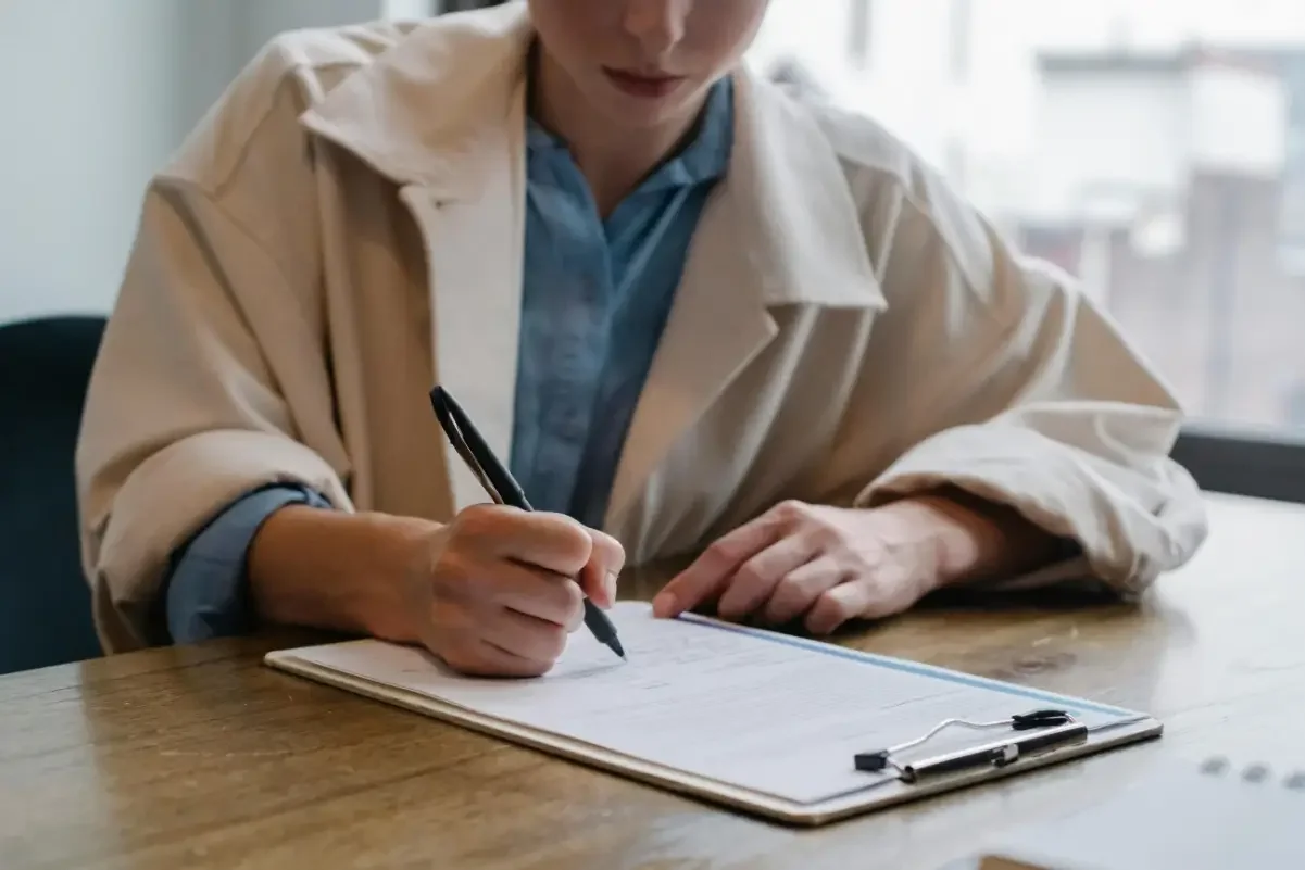 Person sitting at a table filling out a form