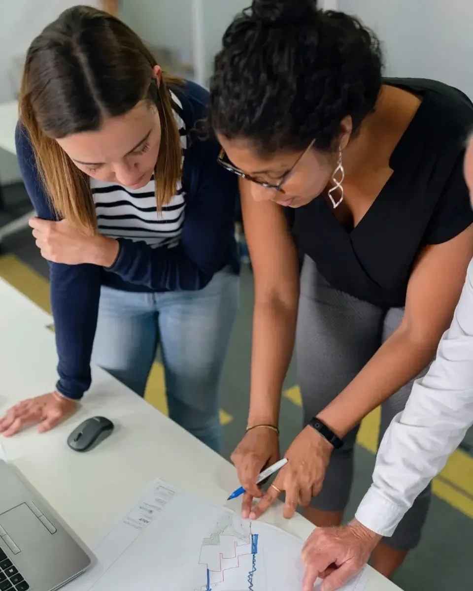 Two people standing over a table looking at plans