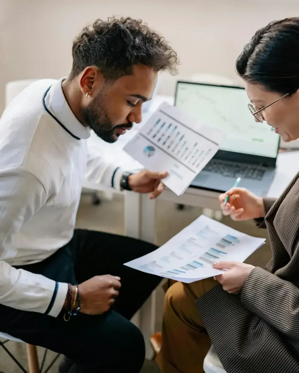 Two people reviewing charts and graphs