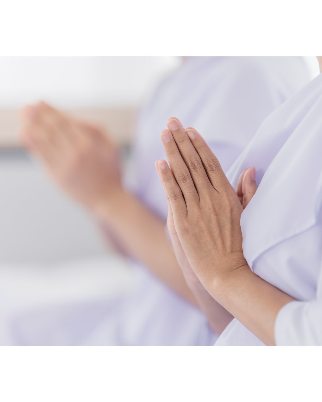 Two healthcare professionals with hands in a prayer or meditation gesture, wearing white uniforms.