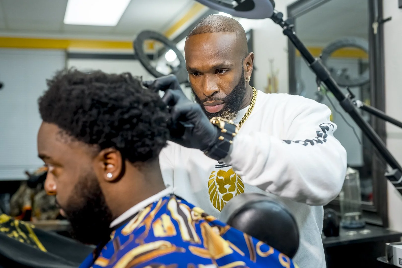 A barber cutting a man's hair in a barbershop.