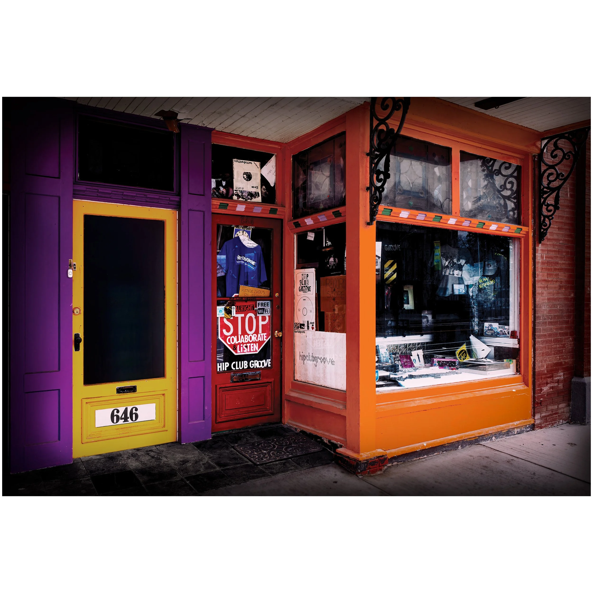 Colorful storefront with purple, yellow, red, and orange painted trims and black wrought iron decorative elements.